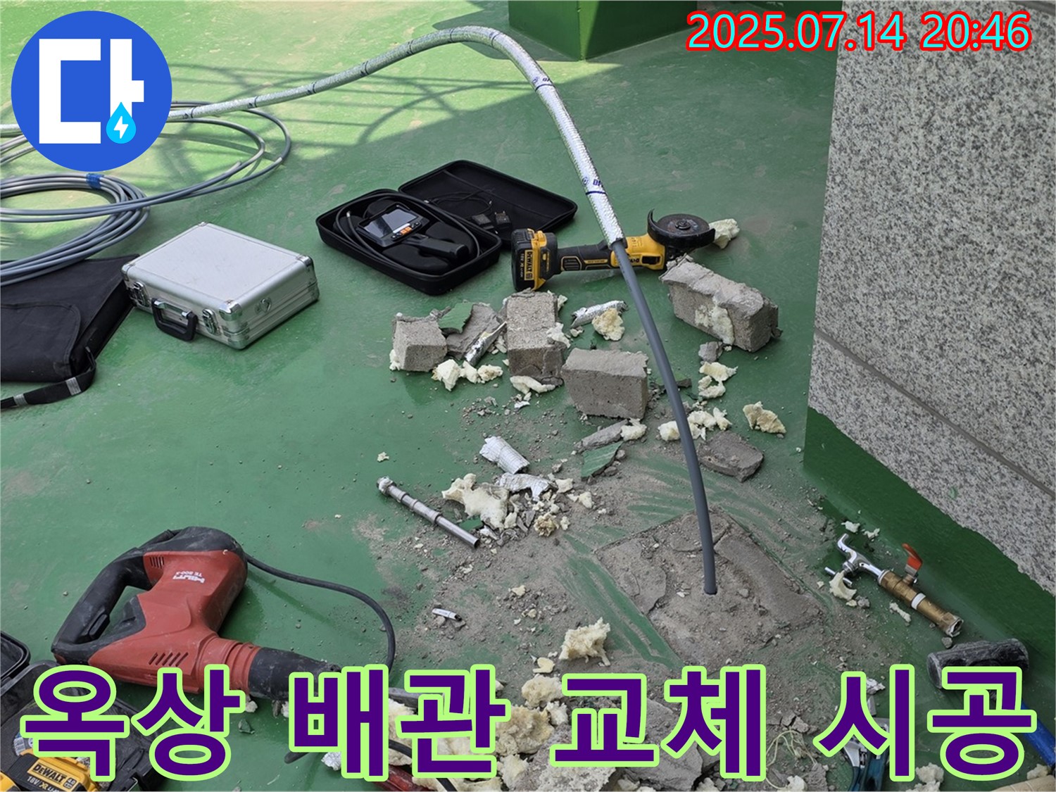 옥상에서 배관 교체 작업을 진행하는 모습 - 동파된 배관을 제거하고 새 배관을 연결하고 있습니다.