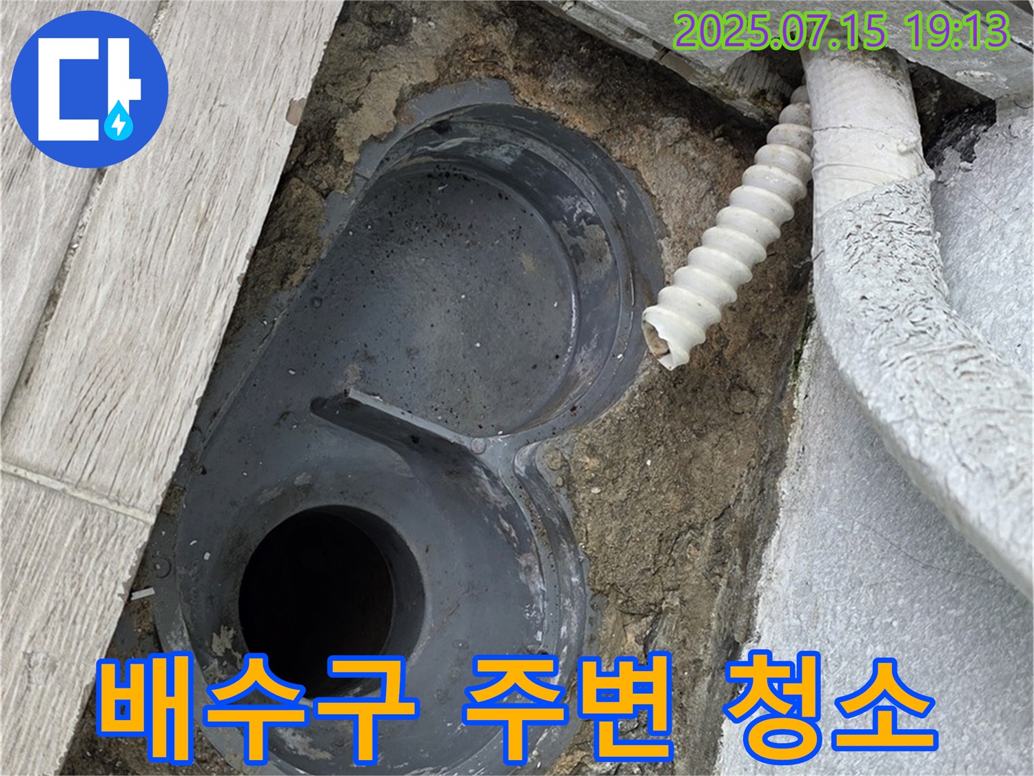 배수구 주변 방수 작업을 위한 꼼꼼한 청소 - 석션 장비를 사용하여 먼지와 이물질을 제거하고 있습니다.