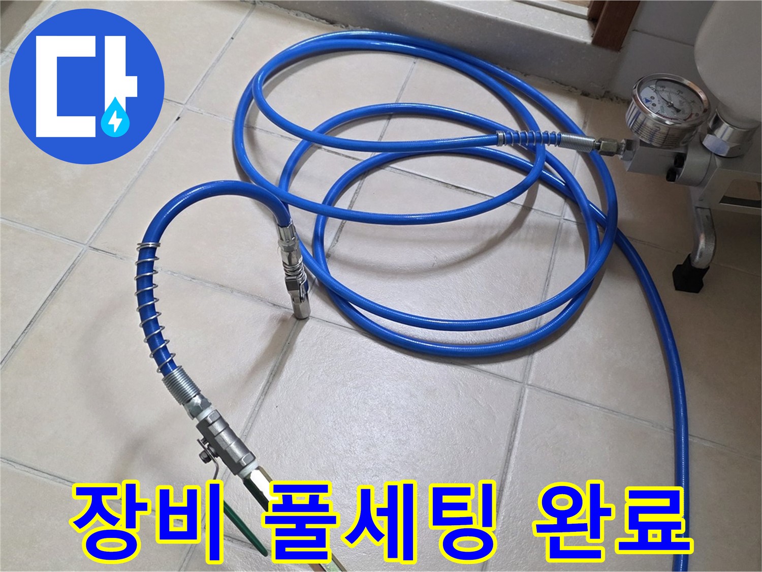 화장실 바닥 타일 위로 파란색 공기압 테스트 호스가 연결되어 있습니다