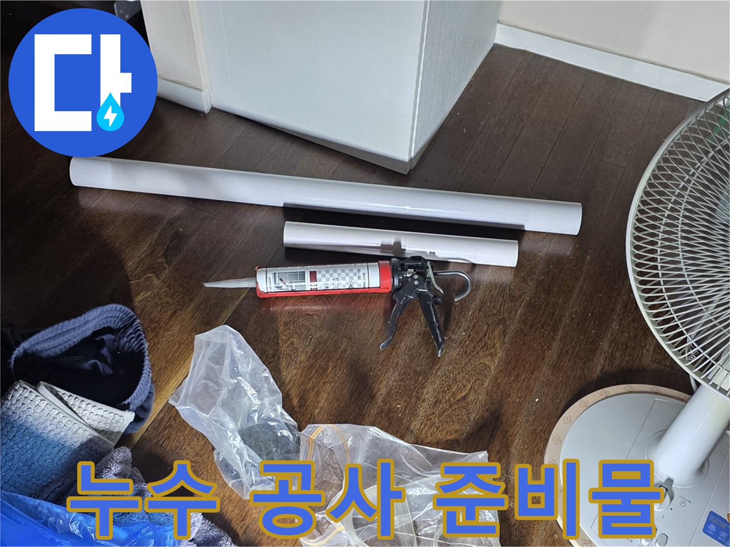 누수 공사를 위한 준비물 - 실리콘과 배관 자재, 그리고 공구들이 가지런히 놓여 있습니다.