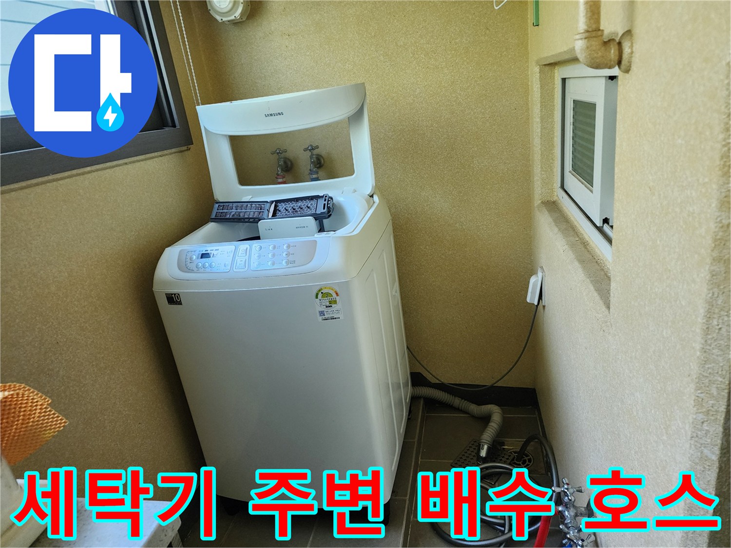 다용도실 세탁기 뒤쪽의 수도 배관과 바닥 배수 연결부 모습