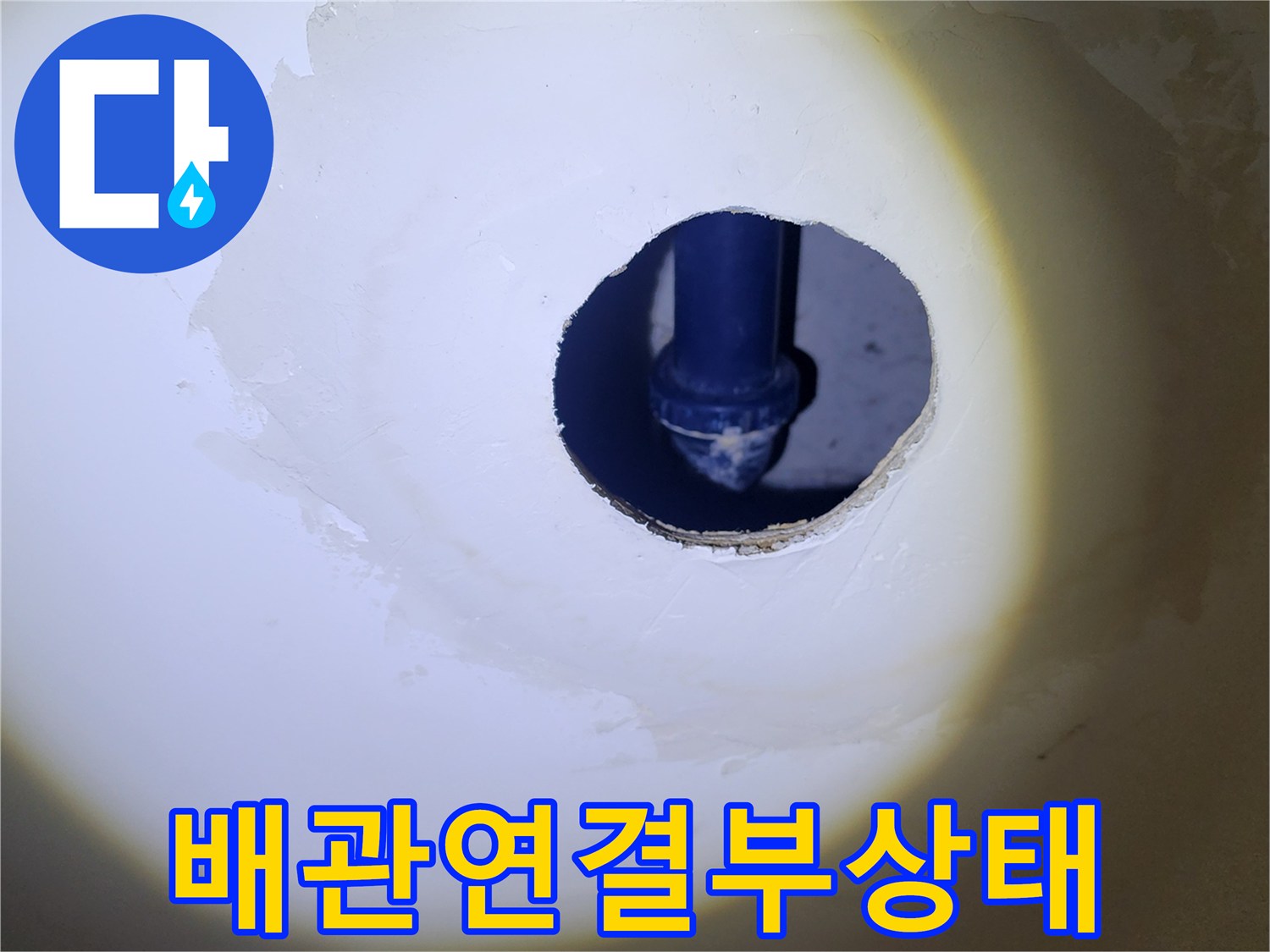 하얀색 마감재 사이로 노출된 배관의 연결 부위를 근접 촬영한 사진입니다.
