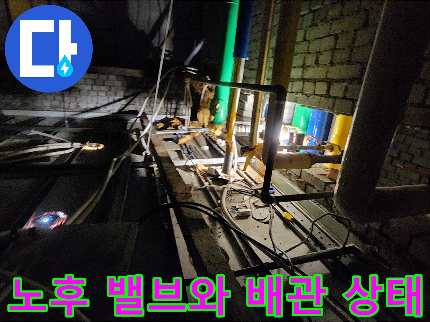 벽돌 벽면 사이의 부식된 금속 배관 및 밸브 상세