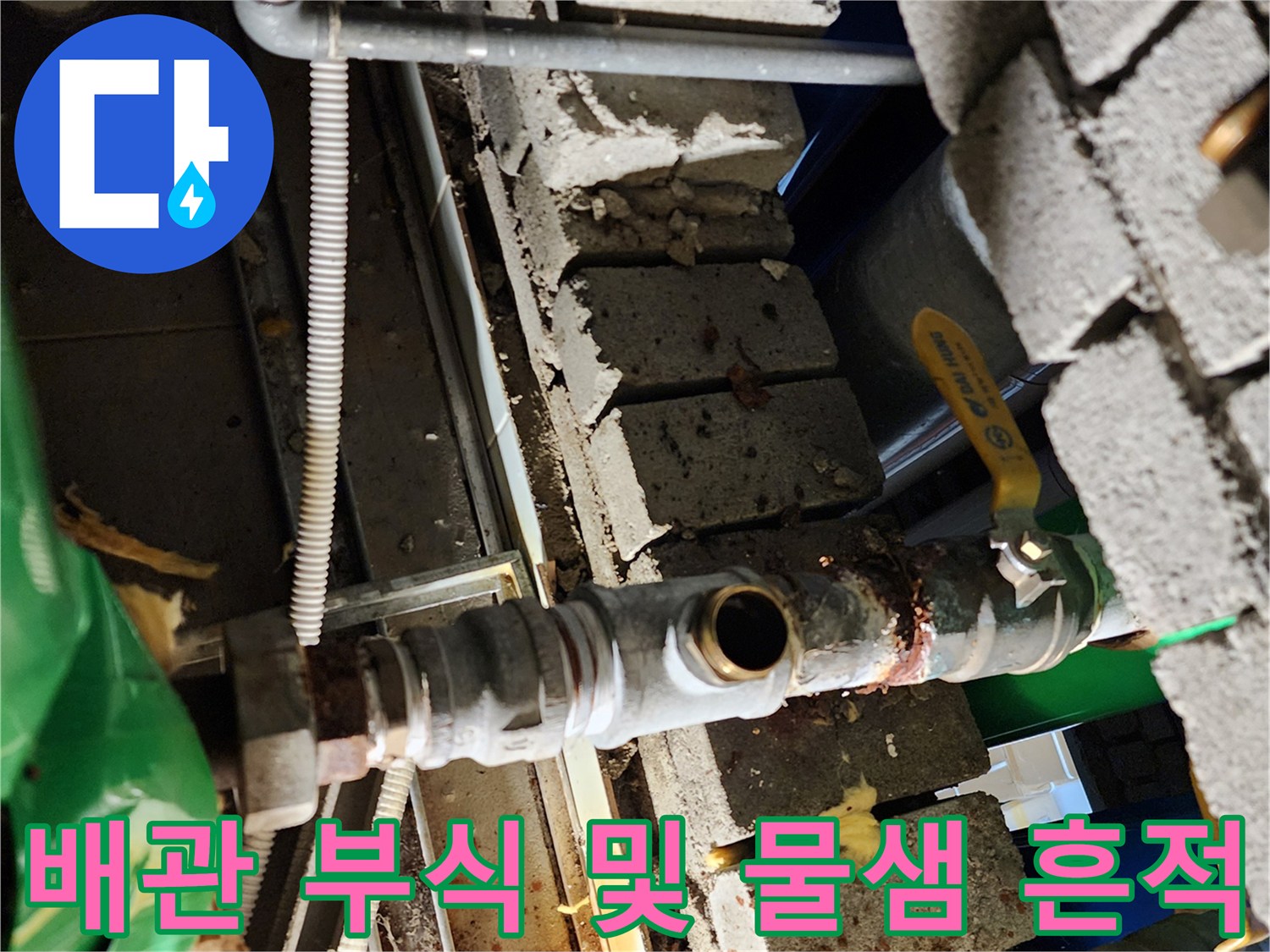 벽돌 사이 노후된 금속 배관과 밸브의 상세 모습