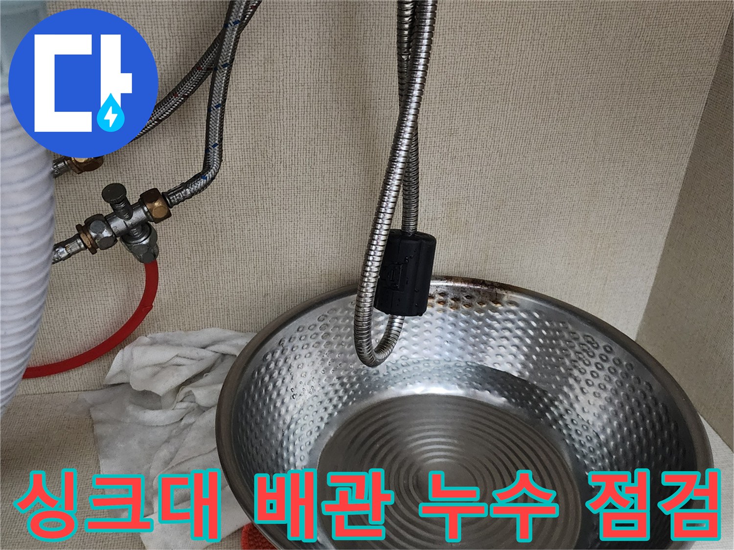 싱크대 아래쪽-금속 재질의 급수 호스 및 연결 부위