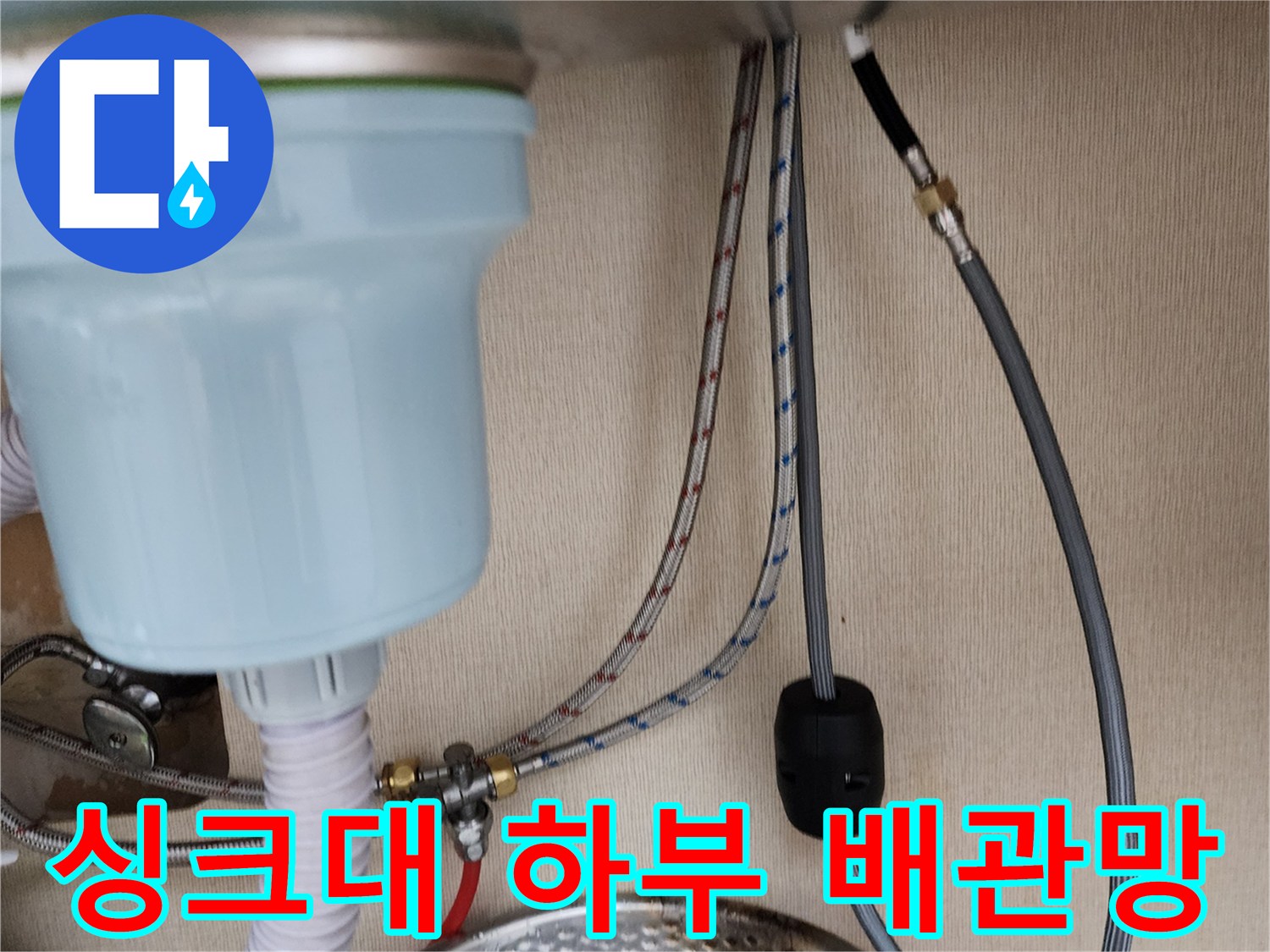 싱크대 아래쪽의 다양한 배관 연결 상태를 보여주는 사진