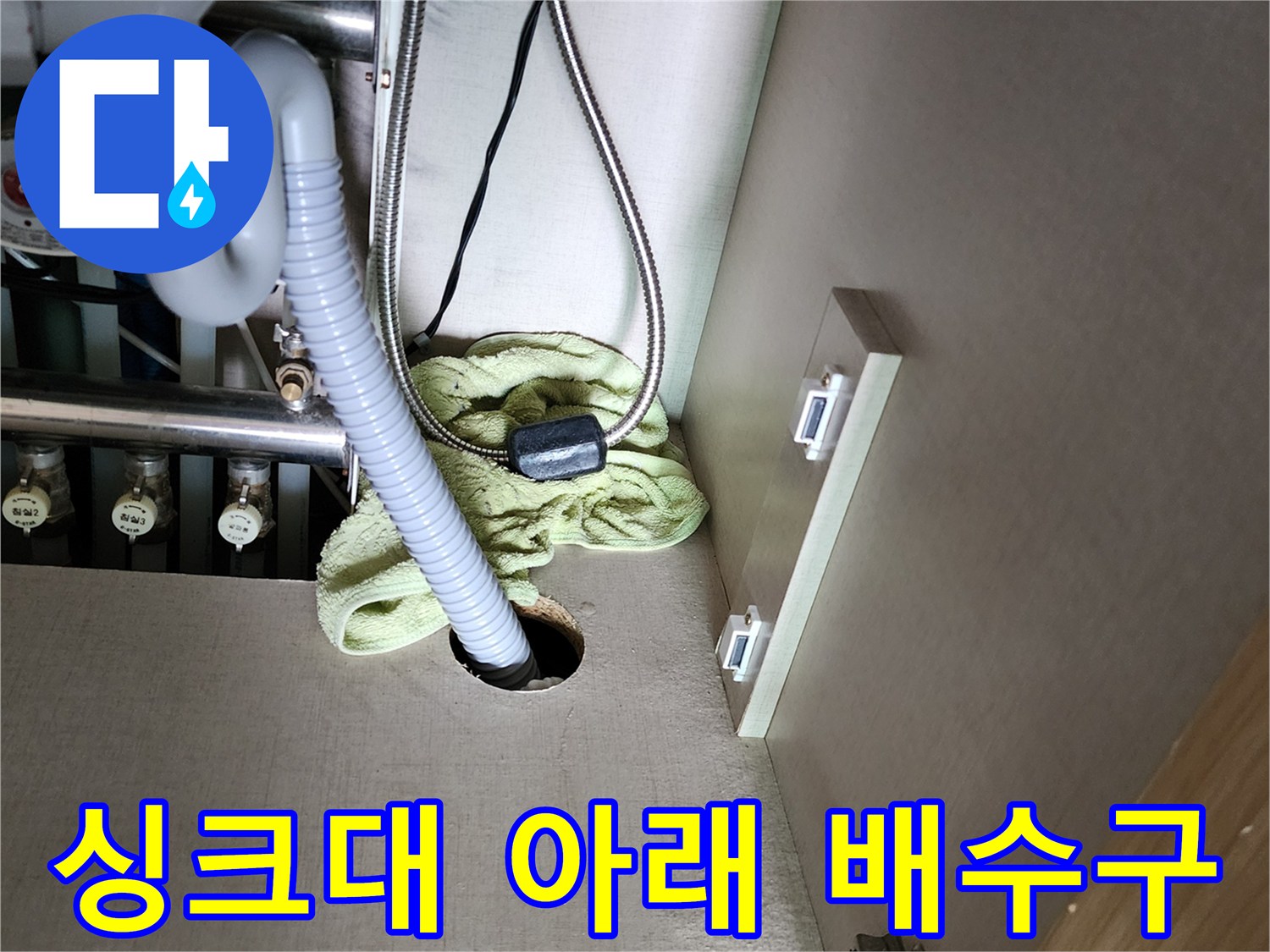 싱크대 하부장의 배수 호스와 바닥 배관 연결 부위 근접 촬영입니다.