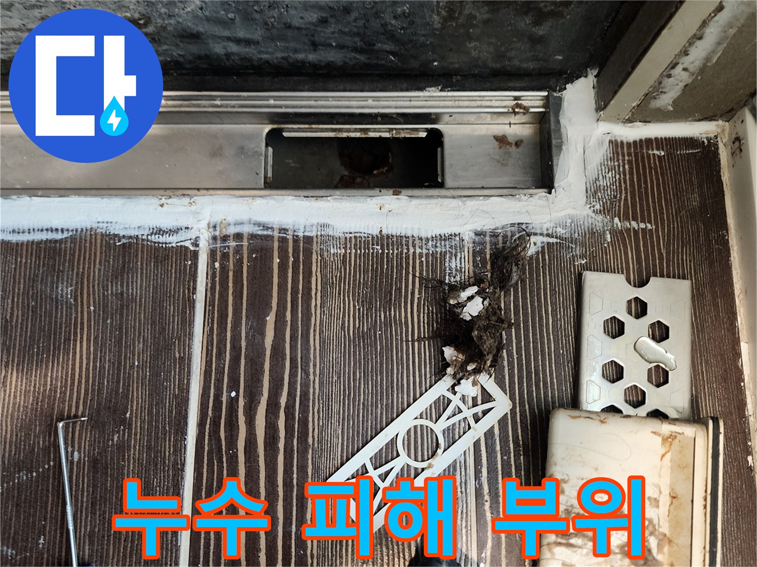 싱크대 밑 바닥 틈새에 스며든 물기와 오염된 자재의 모습입니다.