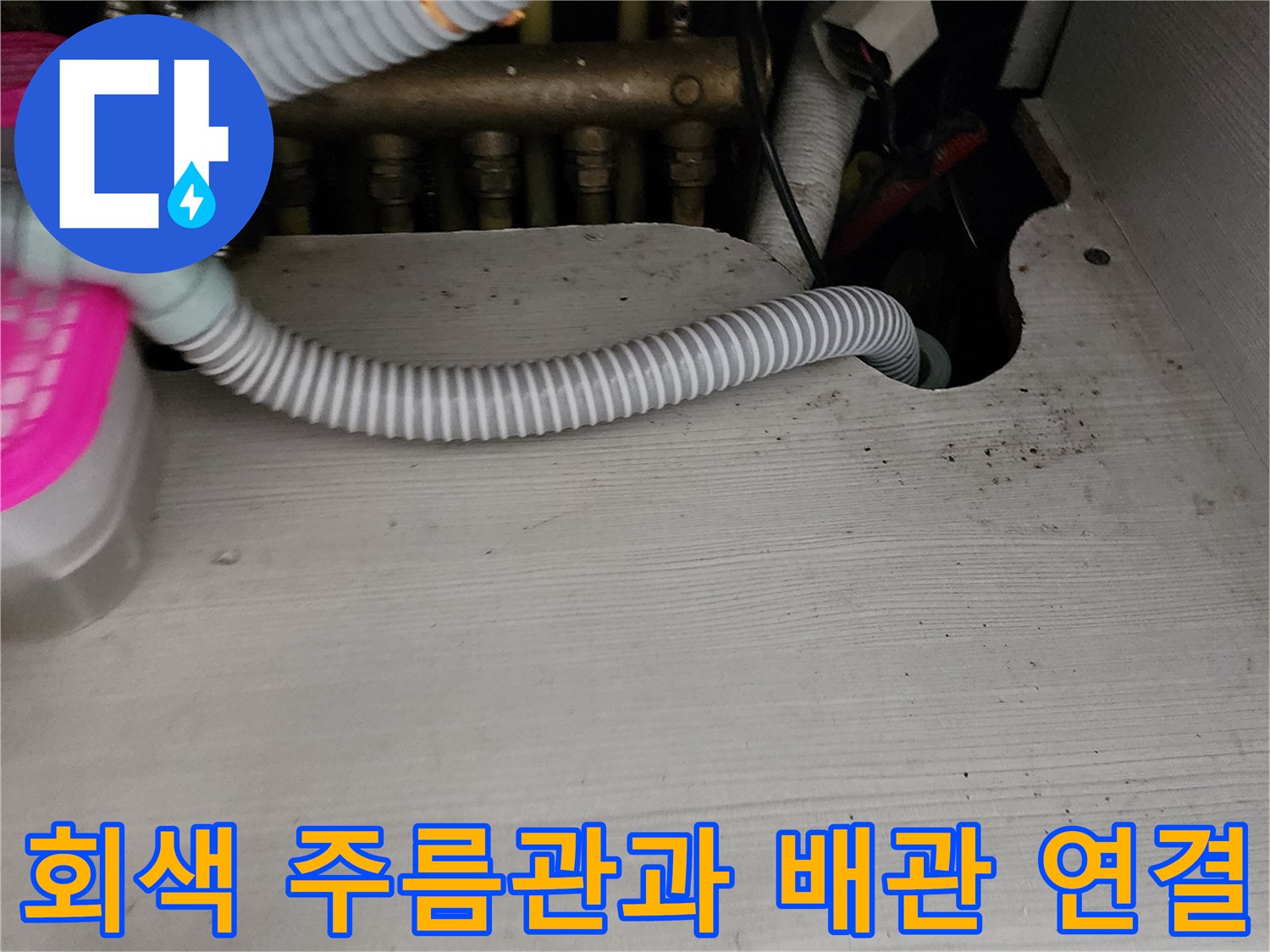 싱크대 밑 배수 호스와 금속 배관의 복합적인 모습