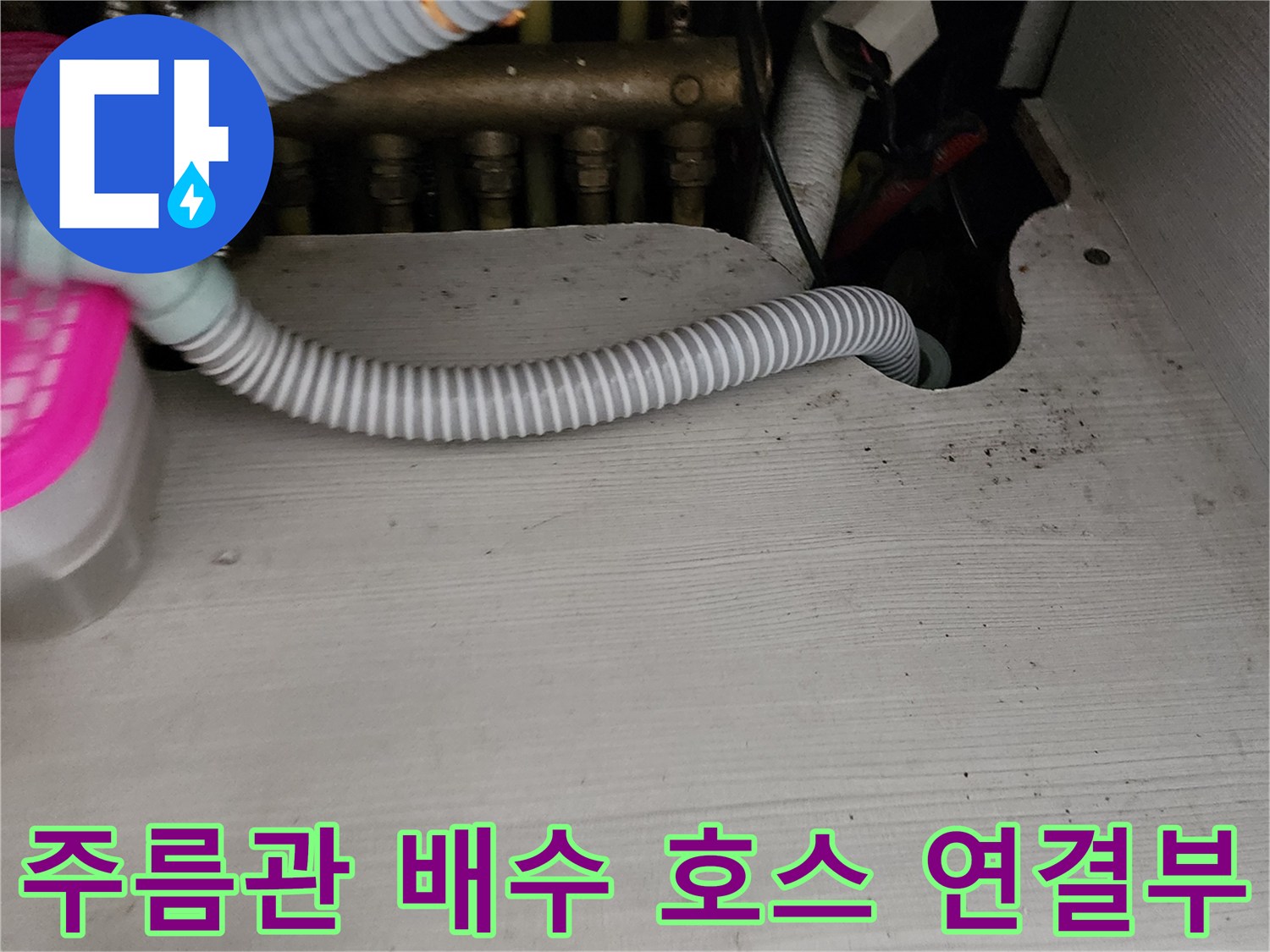 싱크대 하단 자재와 회색 주름관이 연결된 모습