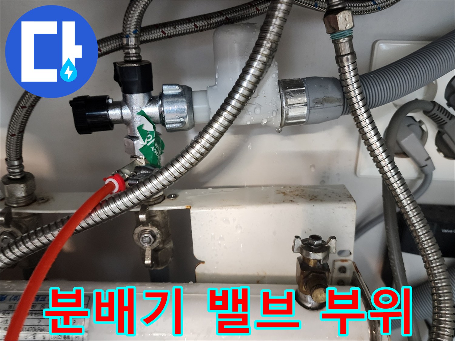 금속 재질의 배관 호스와 하얀색 분배기 본체가 연결된 모습