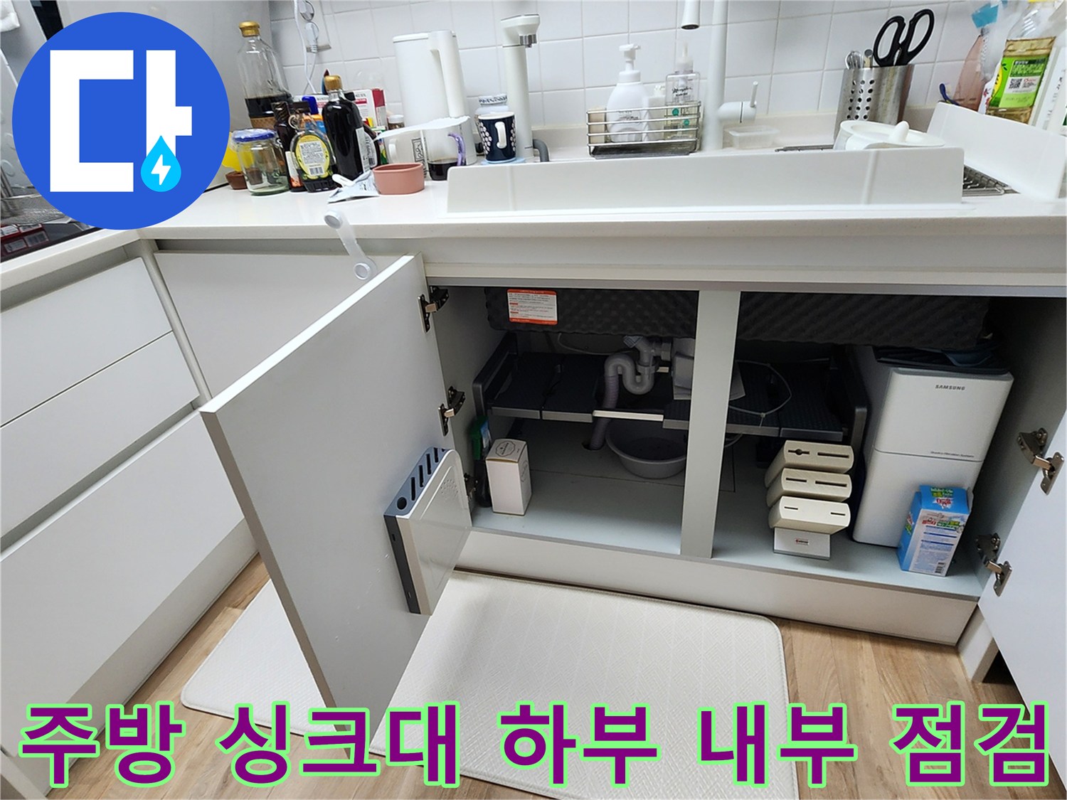 싱크대 아래쪽 배수관과 분배기가 보이는 내부 공간 사진