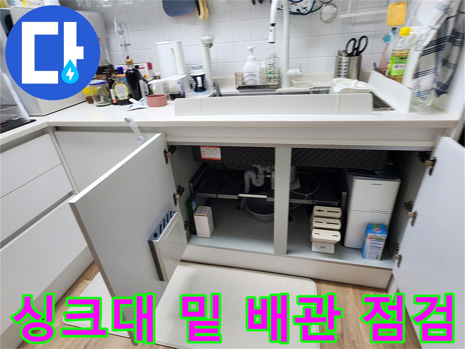 싱크대-하부장-내부의-배관과-주변-기구들을-살펴보는-현장