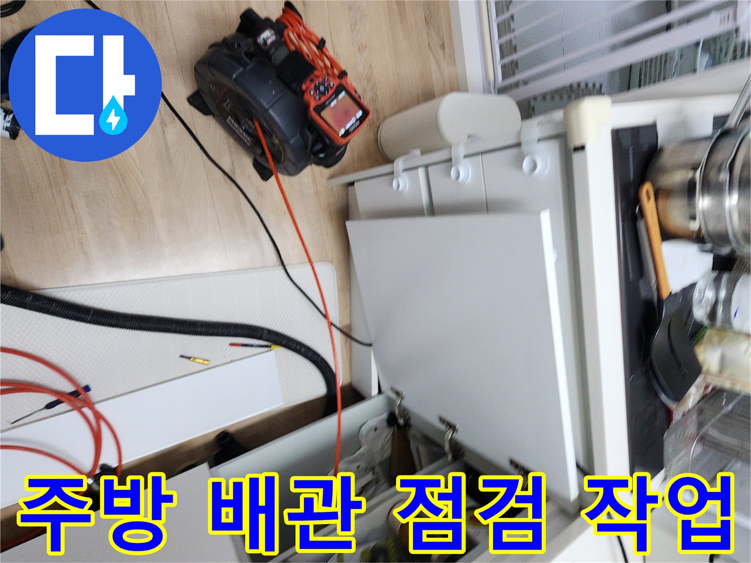 싱크대 하부장 아래 공간에 배치된 내시연 장비와 케이블입니다.