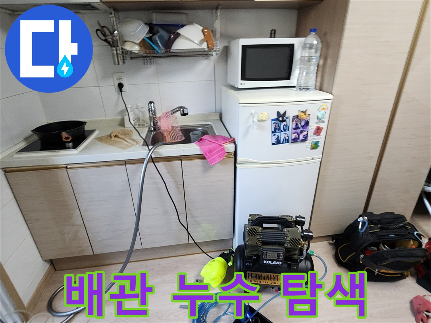 싱크대 밑 배관의 압력을 체크하기 위해 연결된 콤프레샤와 호스 라인