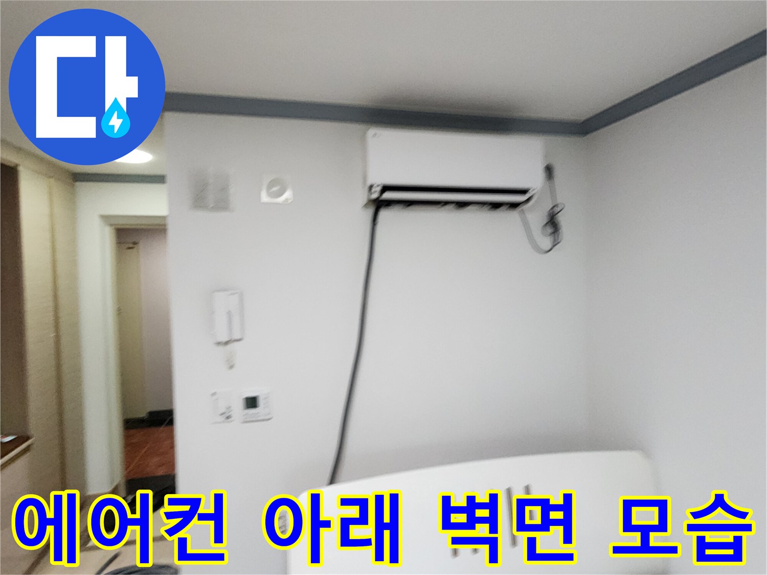 하얀색 에어컨과 벽면에 연결된 검은 배관입니다.