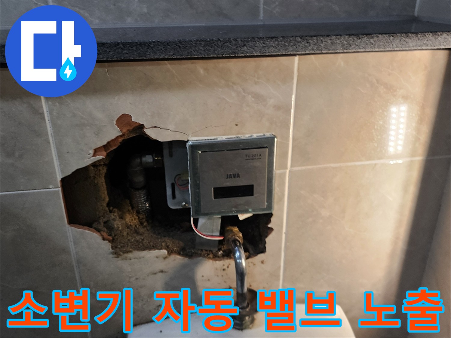 타일 제거 후 드러난 소변기용 자동 세척 밸브와 하단 급수관의 상태입니다.