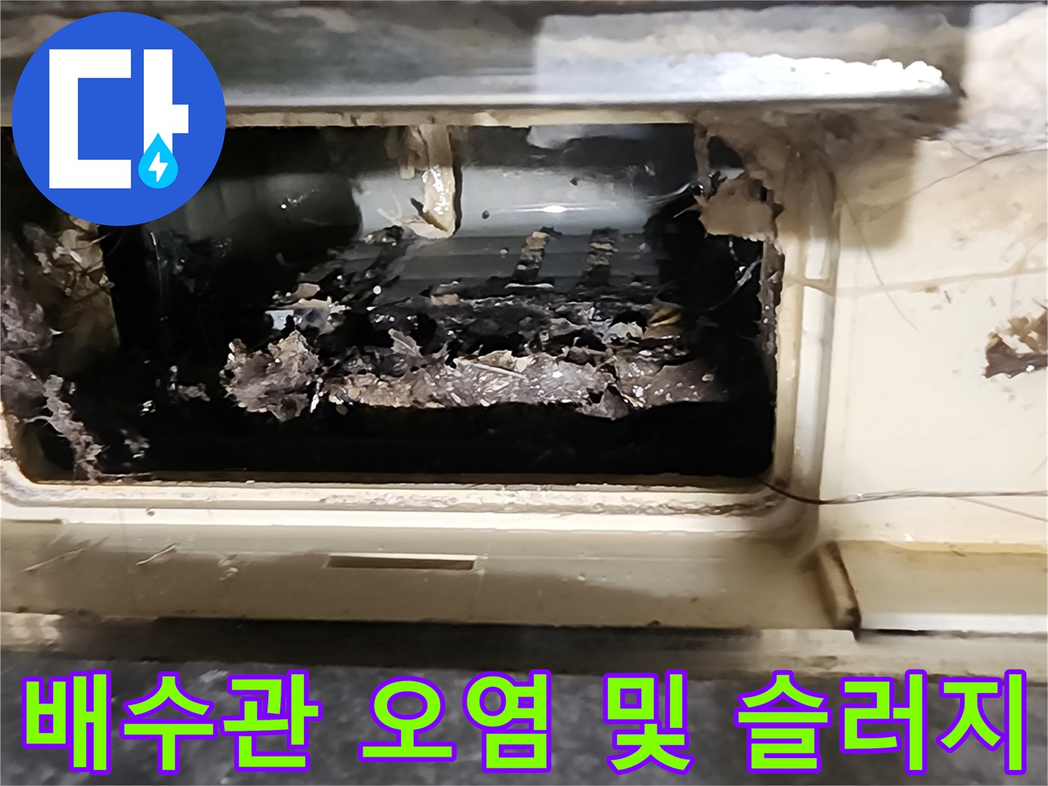 배관 주위에 젖은 이물질과 검은색 오염물이 관찰됩니다.