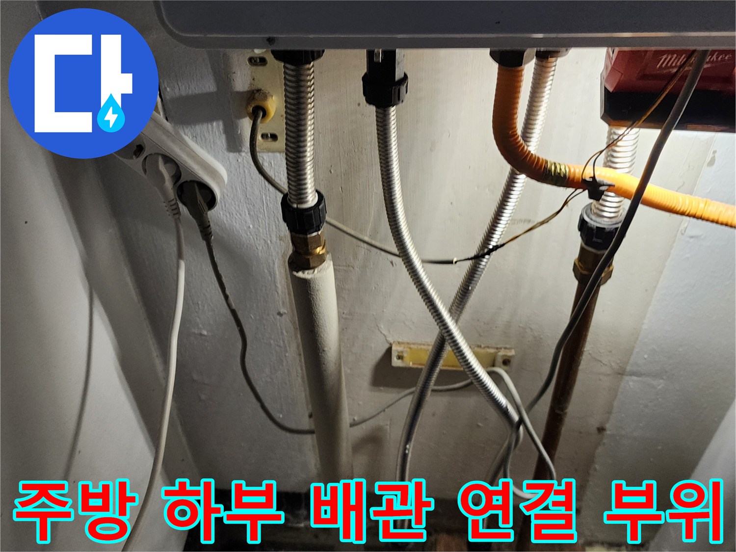싱크대 아래쪽 은색 주름관과 노란색 호스의 복합적인 연결 구조