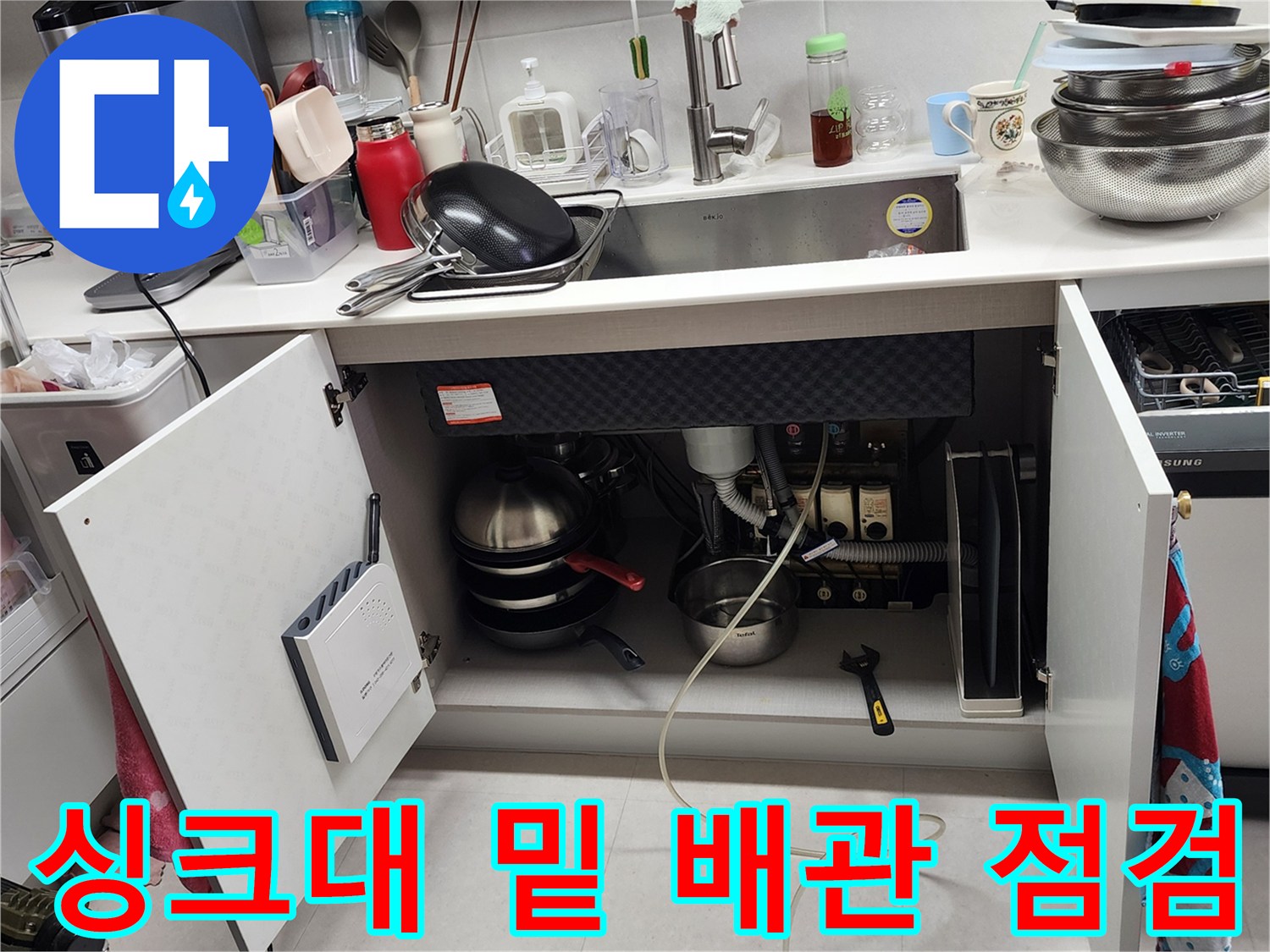 싱크대 하부장 내부의 노후된 배수 호스와 연결 소켓 상태