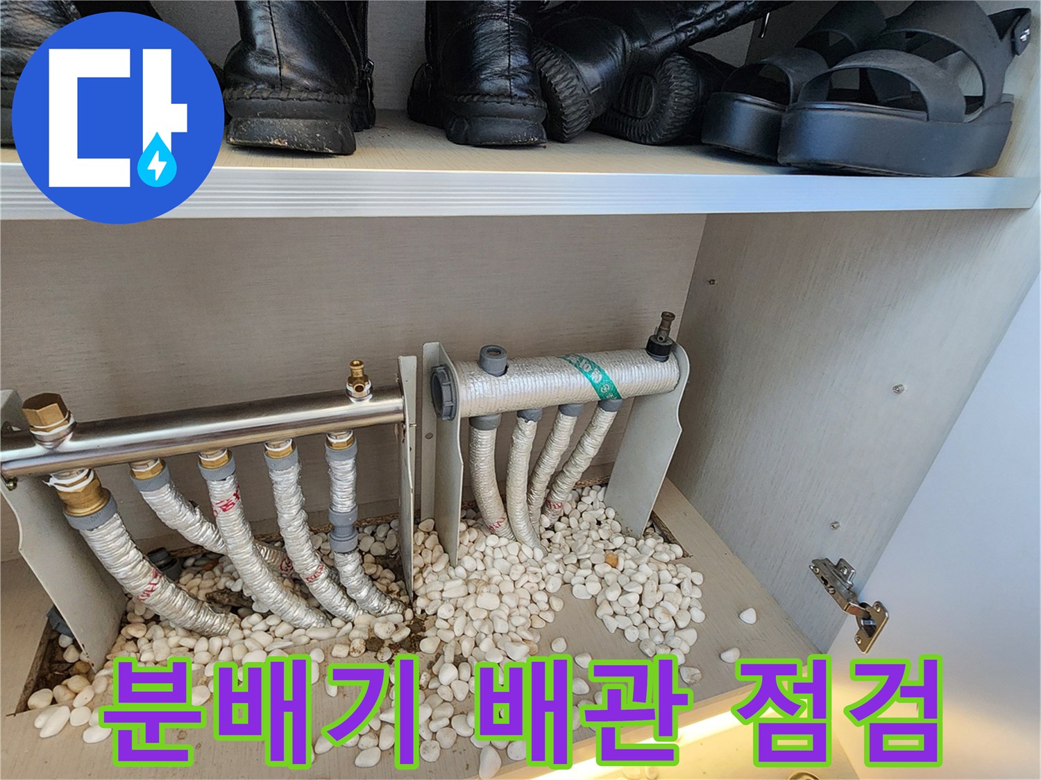 흰색 자갈로 마감된-싱크대 하부장-배관 분배기 모습