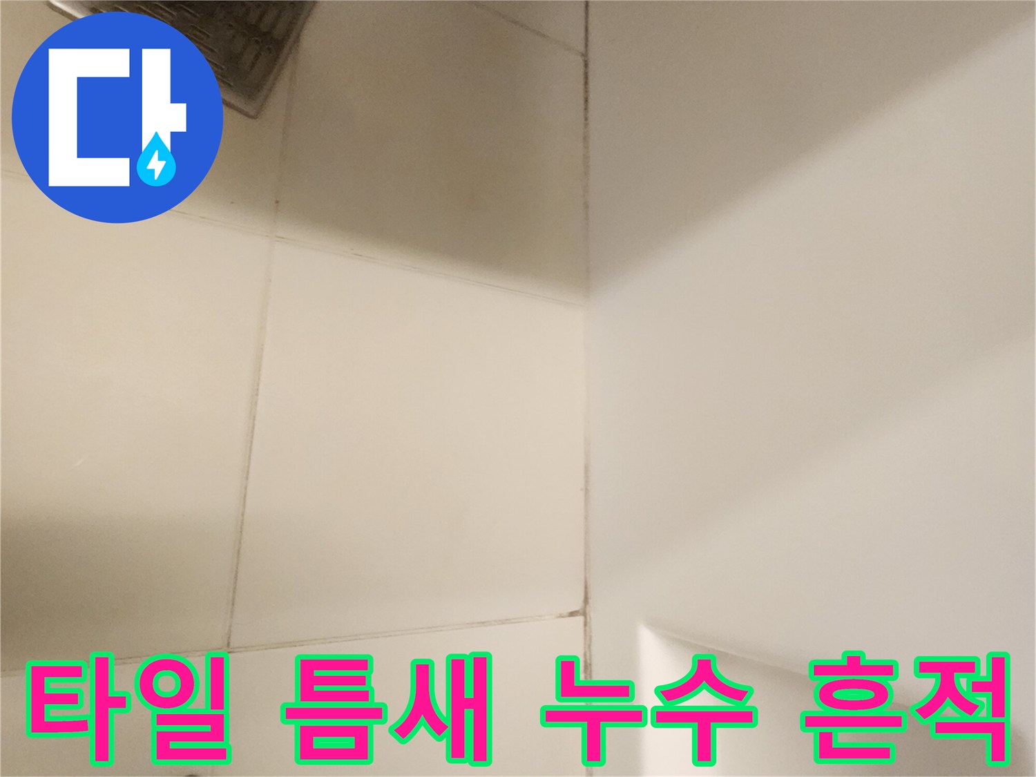하얀 타일과 배수구 유가 사이의 불량한 접합 상태입니다.