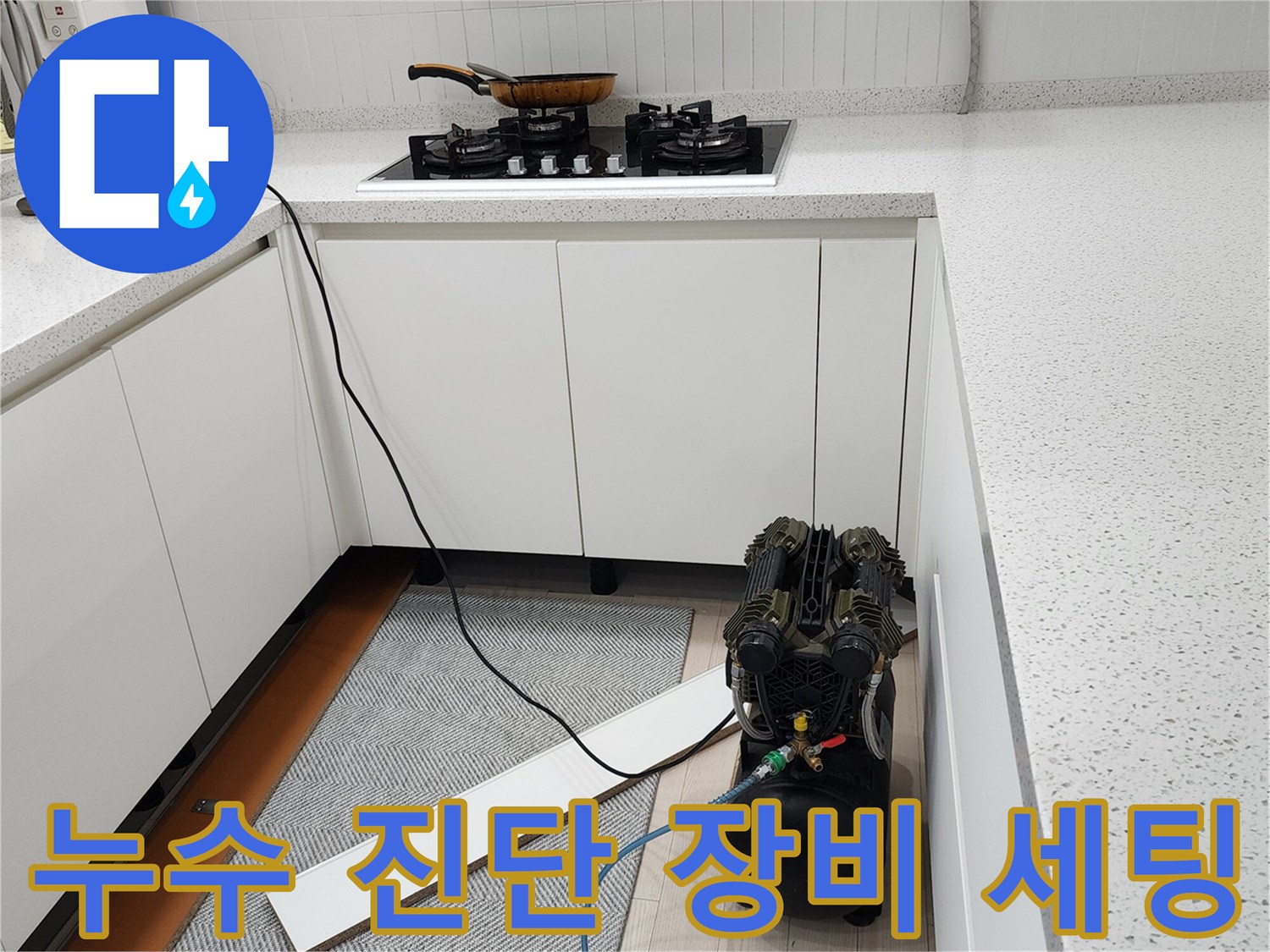 주방 싱크대 하단에 배치된 공압 테스트용 컴프레서와 호스 연결 모습
