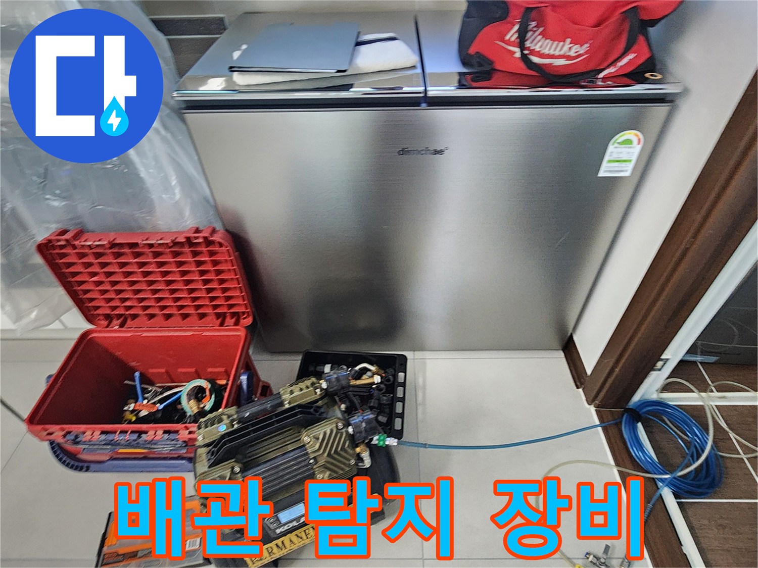바닥에 배치된 배관 누수 탐지용 가스 장비와 압력계