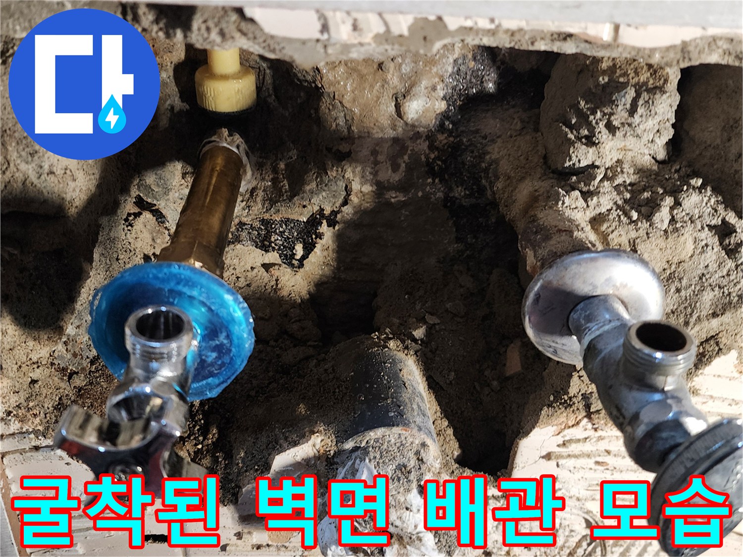 벽면 내부의 수도 밸브와 연결된 배관이 드러난 작업 현장입니다.