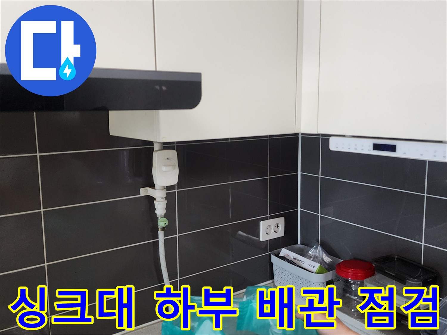 싱크대 아래쪽 수도 관과 벽 타일의 연결 상태 사진