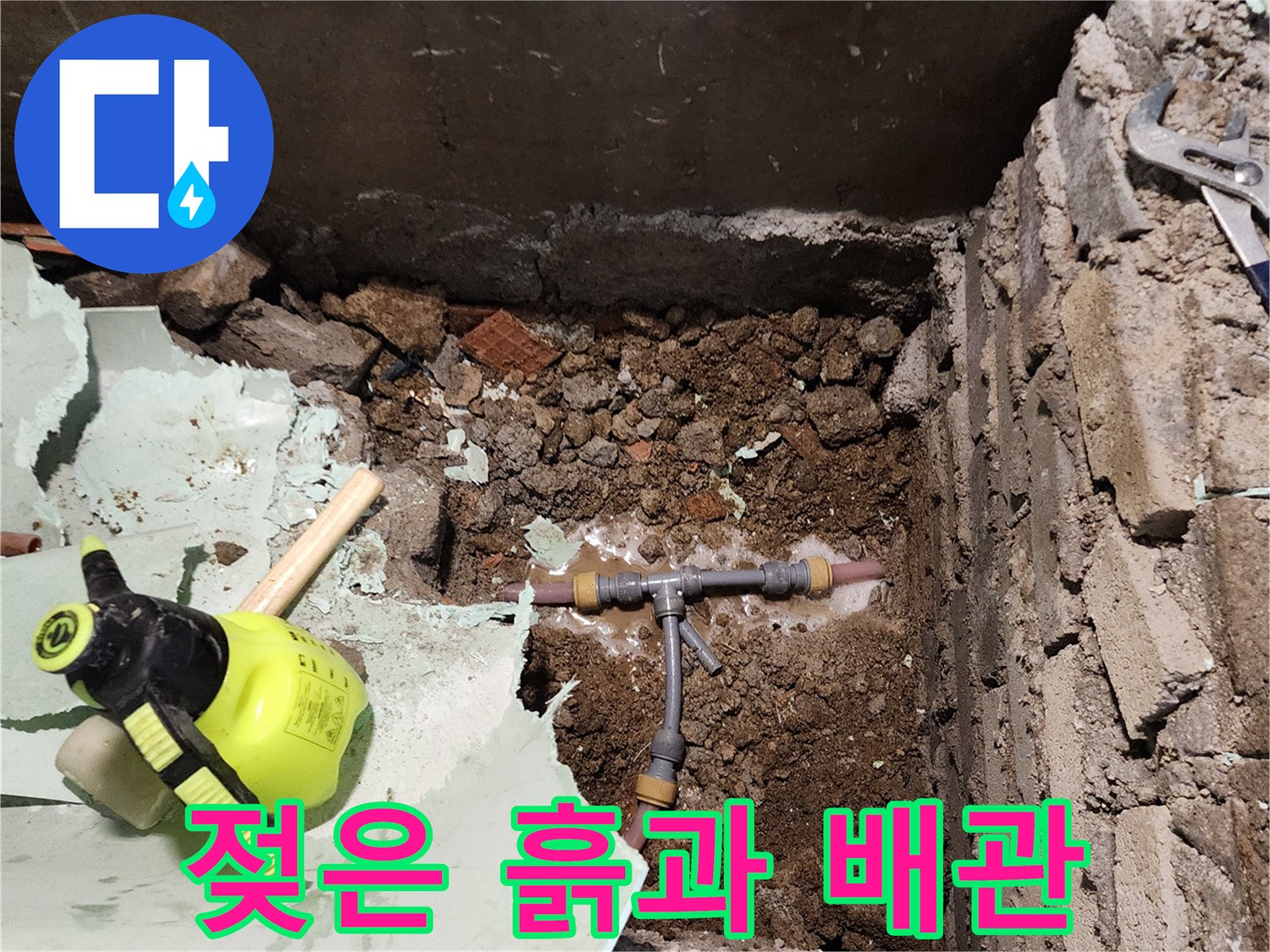 누수 지점 주변의 젖은 토사와 노후 배관