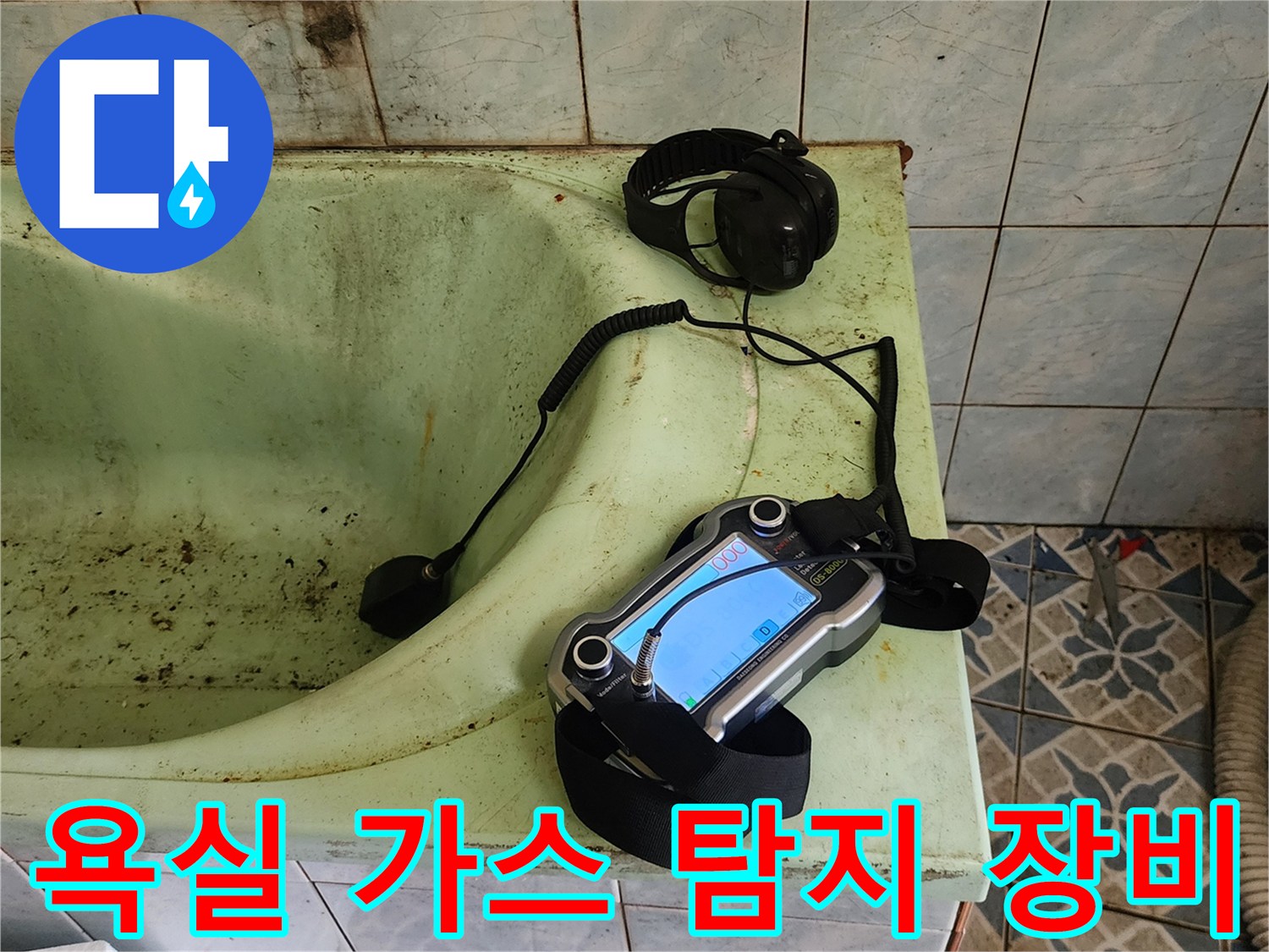 오래된 욕조 옆에 놓인 가스 탐지기와 헤드폰