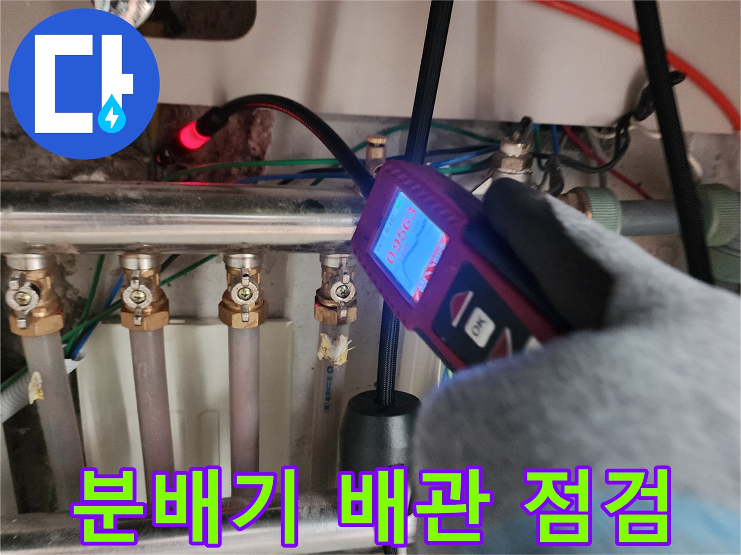 금속제-분배기와-여러-연결-호스에-압력-측정기를-대고-있는-모습
