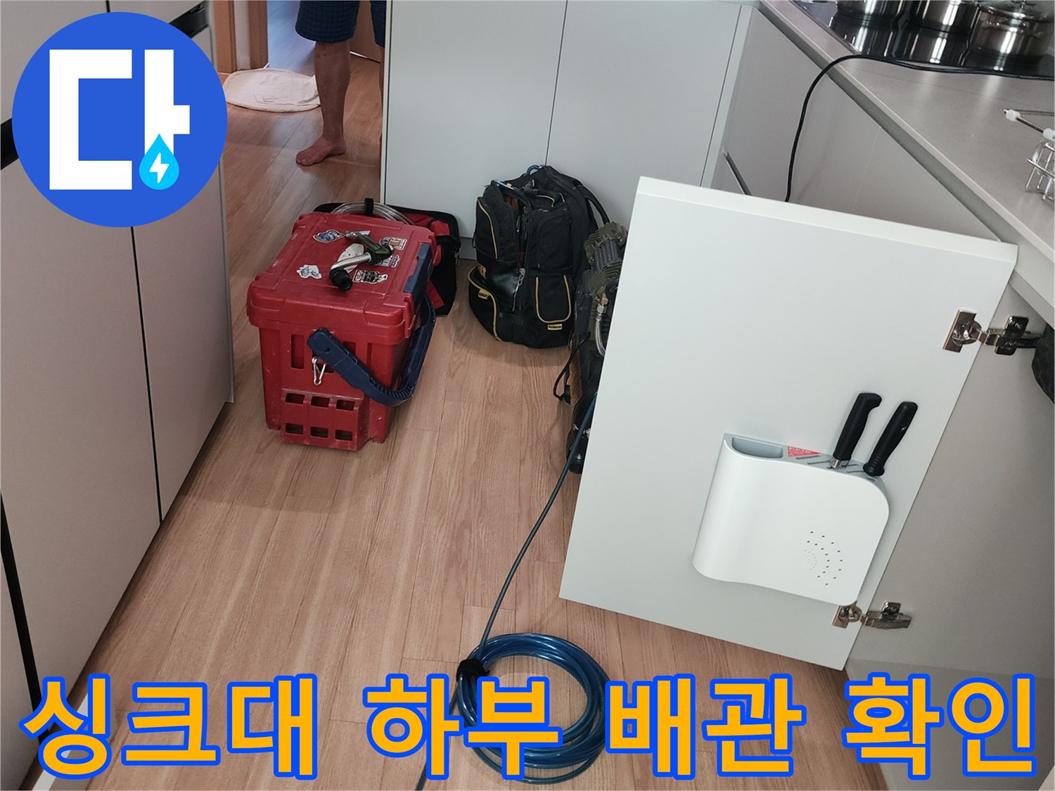 열려있는-싱크대-하부장과-배관-점검-도구들입니다.