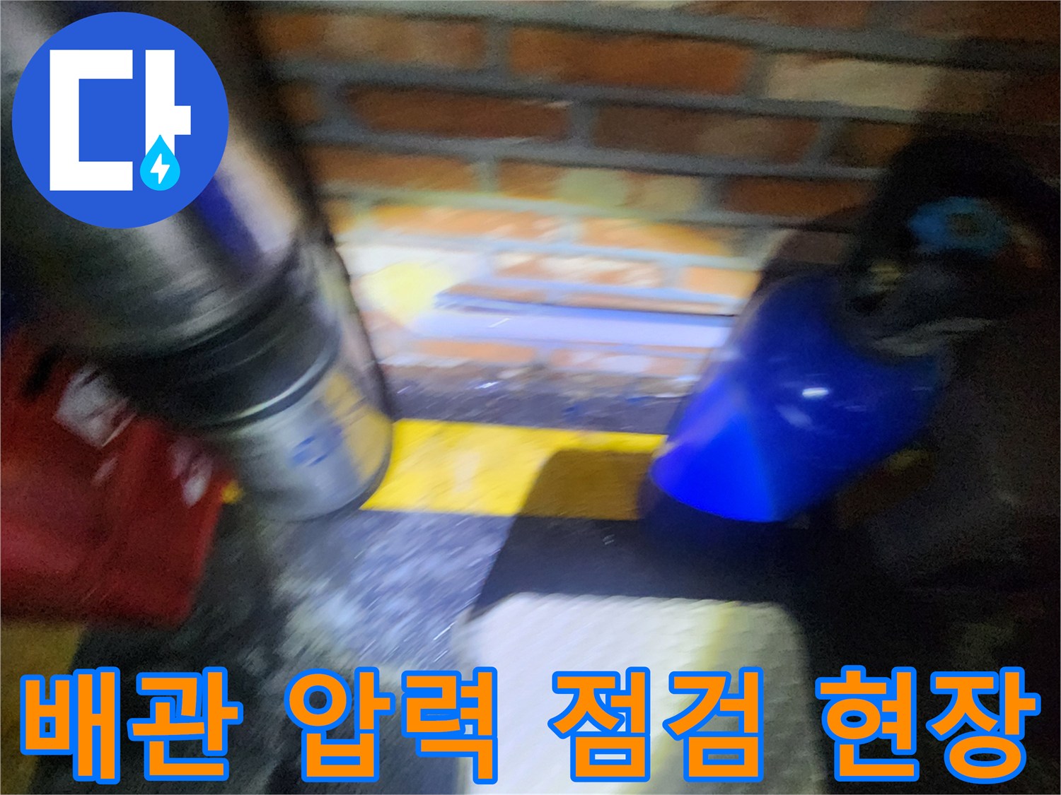 벽돌 구조물 아래의 금속 배관과 테스트 장비가 놓인 모습