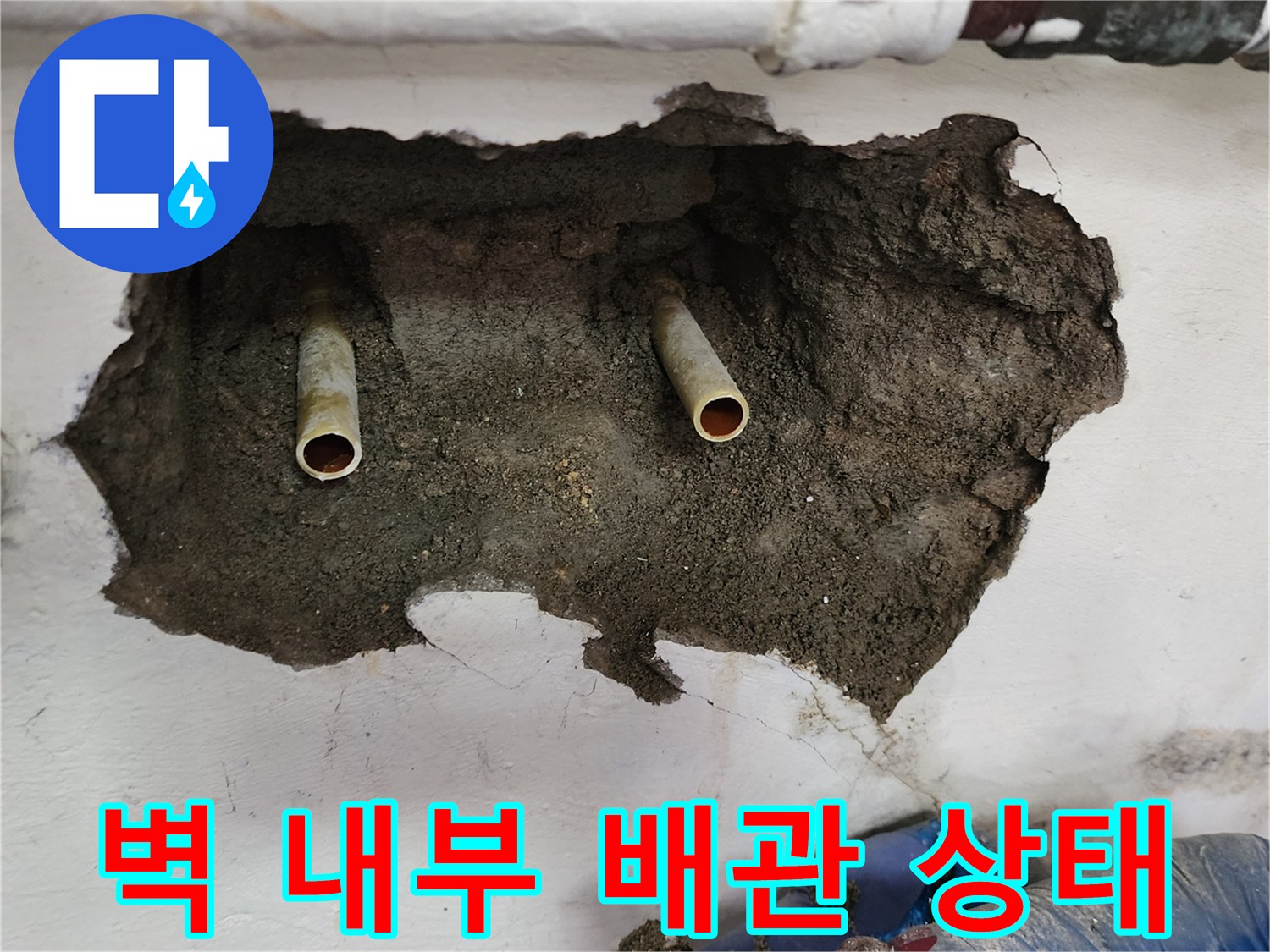 벽면 굴착 부위에 드러난 두 갈래의 급수 배관과 젖은 토사