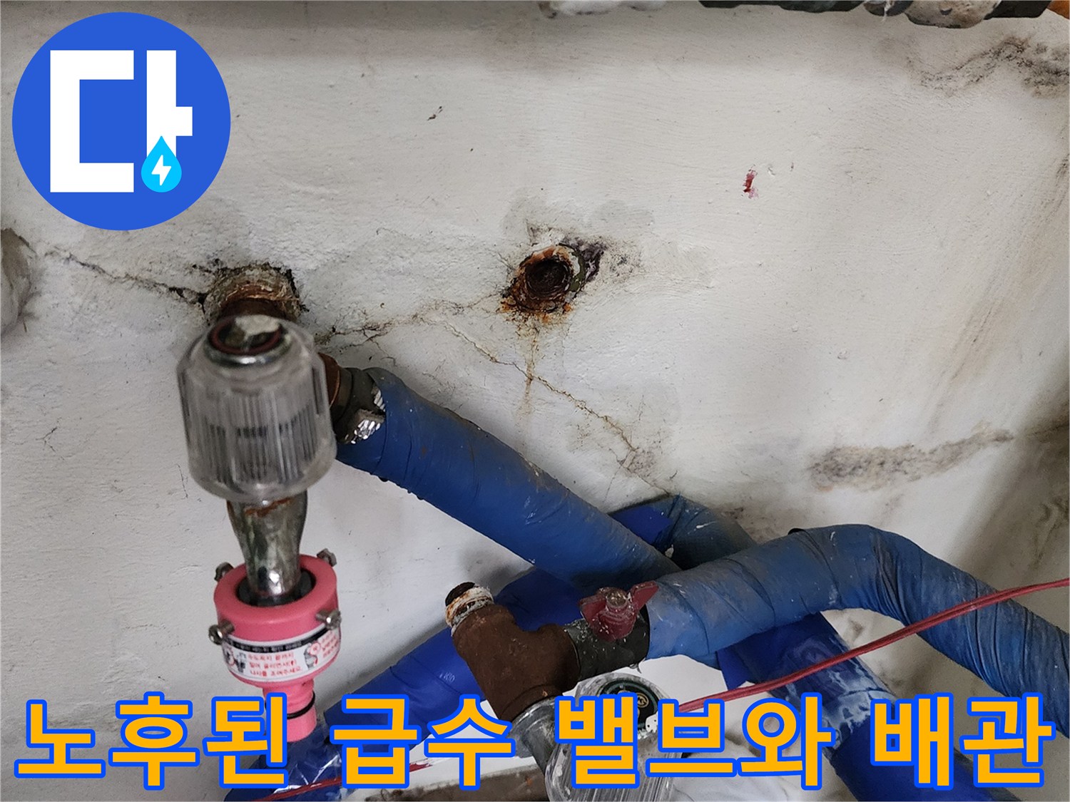 부식된 금속 밸브와 파란색 보온재가 감겨 있는 급수 배관