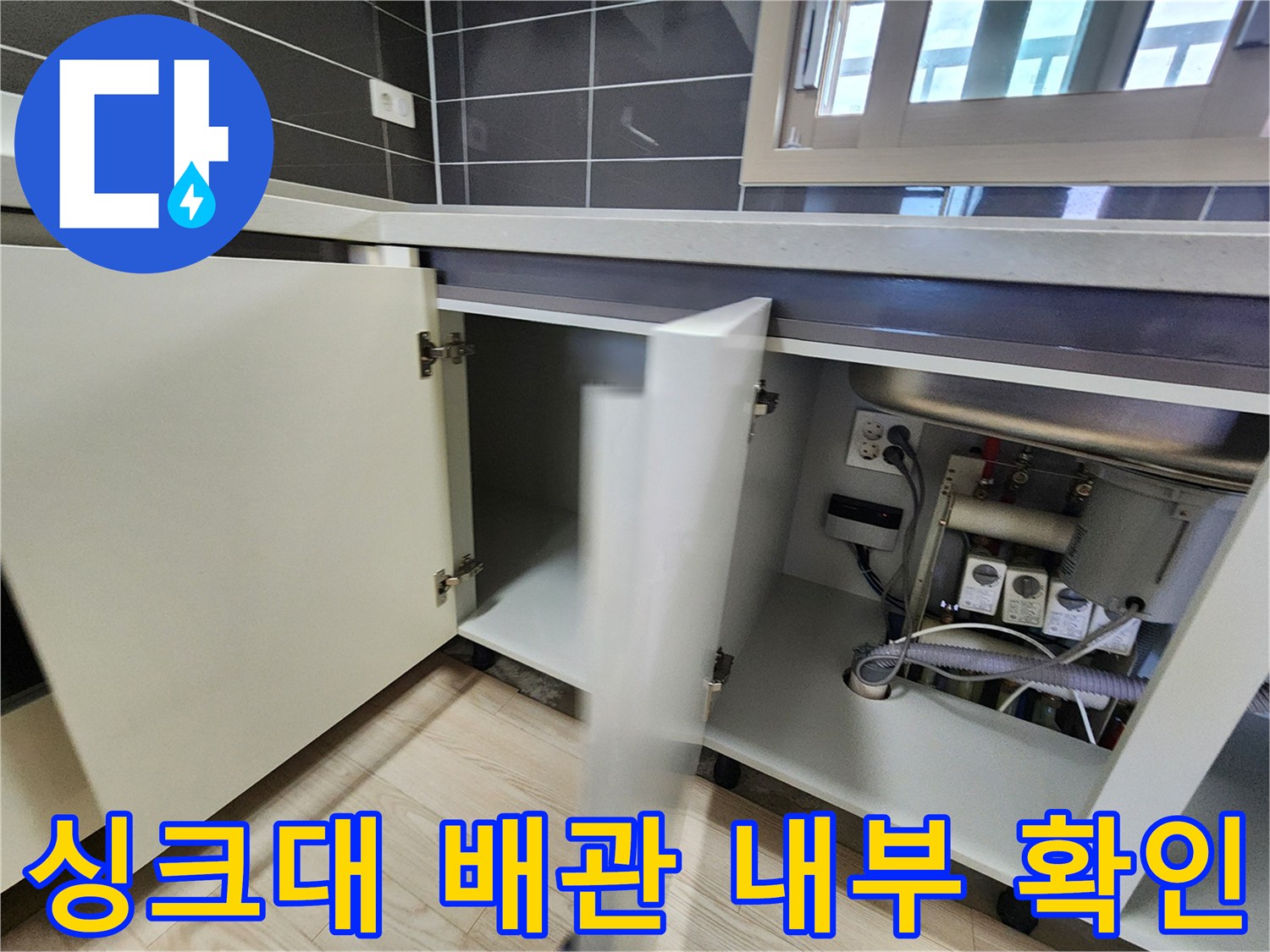 싱크대 밑 공간-배관 연결 부위와 전기 콘센트 노출