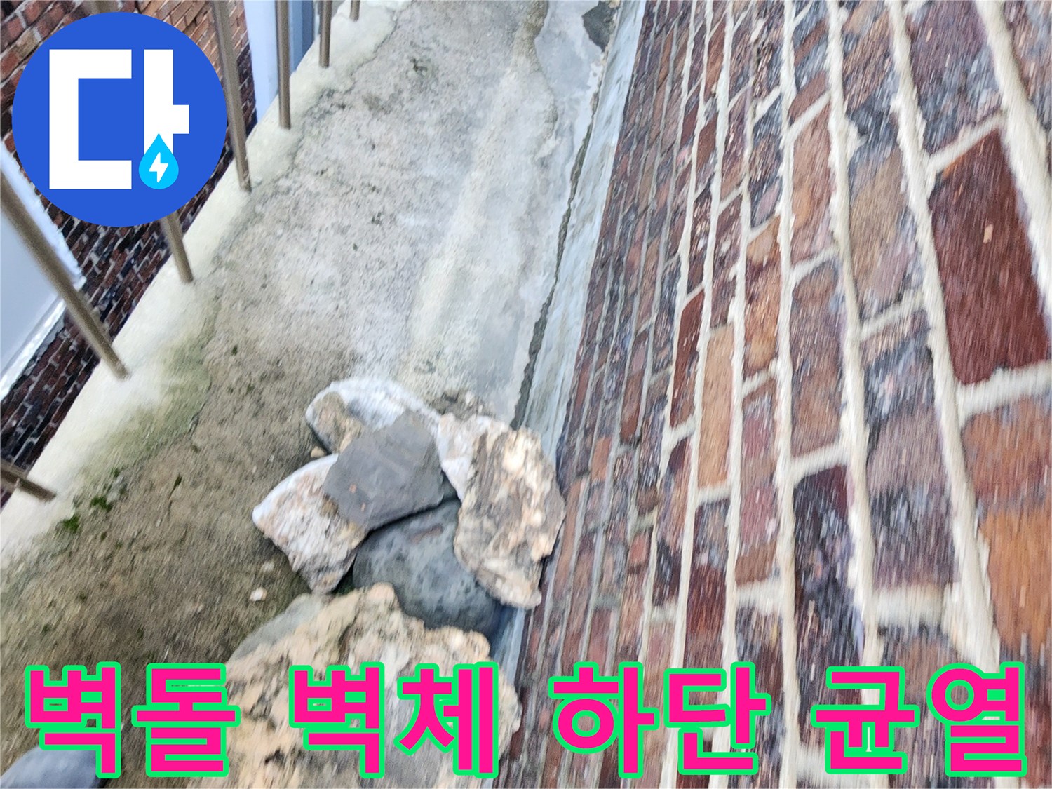 건물 외벽 하단의 갈라진 틈과 거친 지면 상태