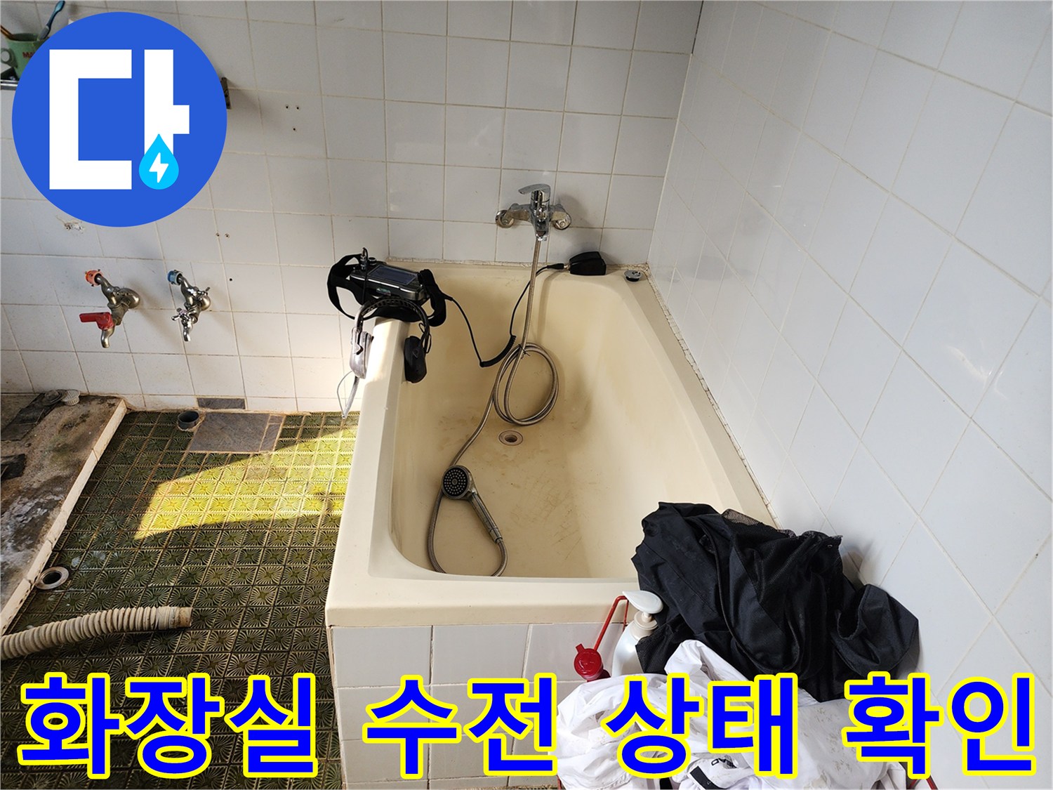 욕실 욕조 근처의 샤워기 수전과 벽면 타일 모습