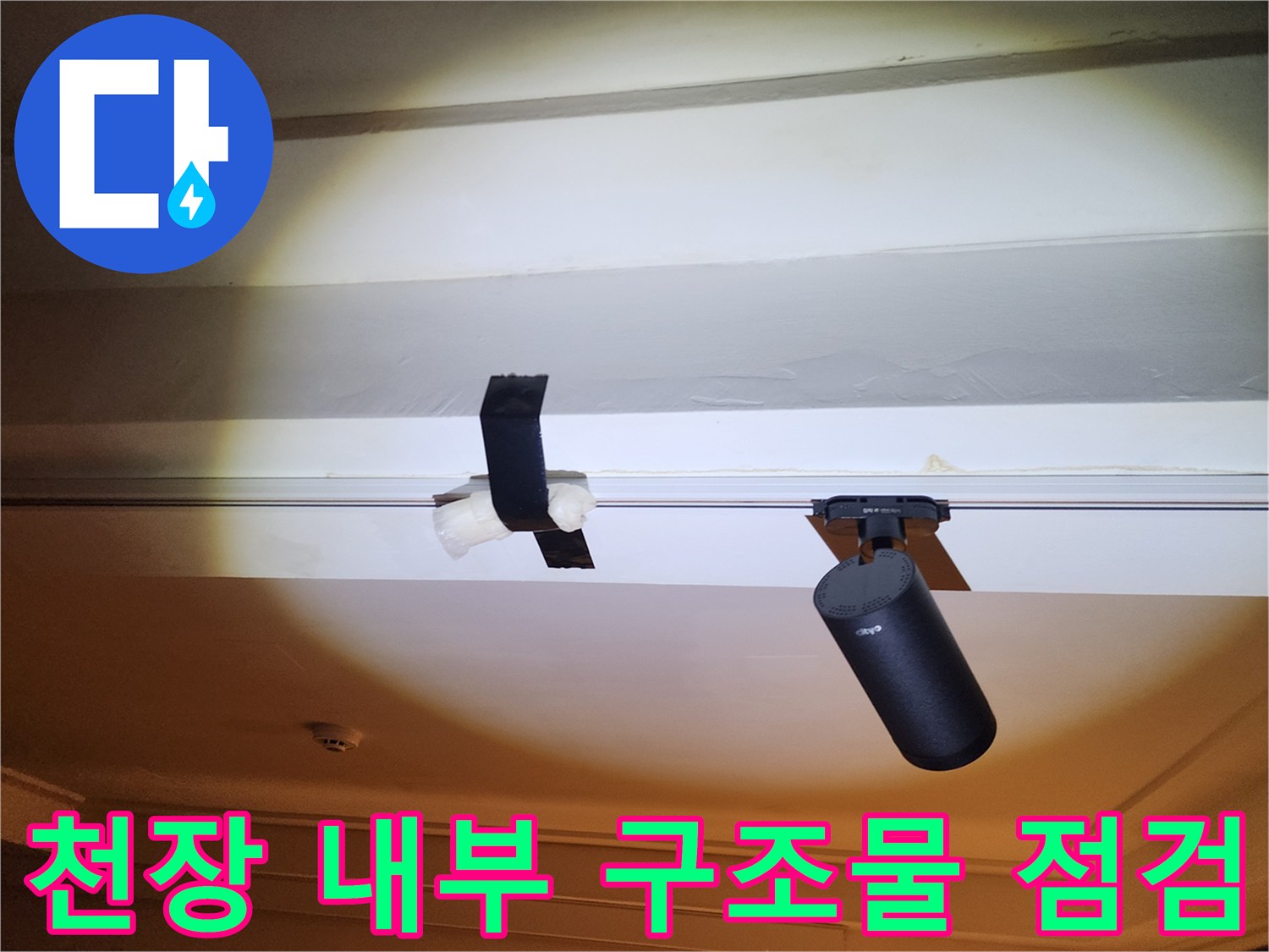천장 틈새에 위치한 검은색 배관 부품과 연결 장치