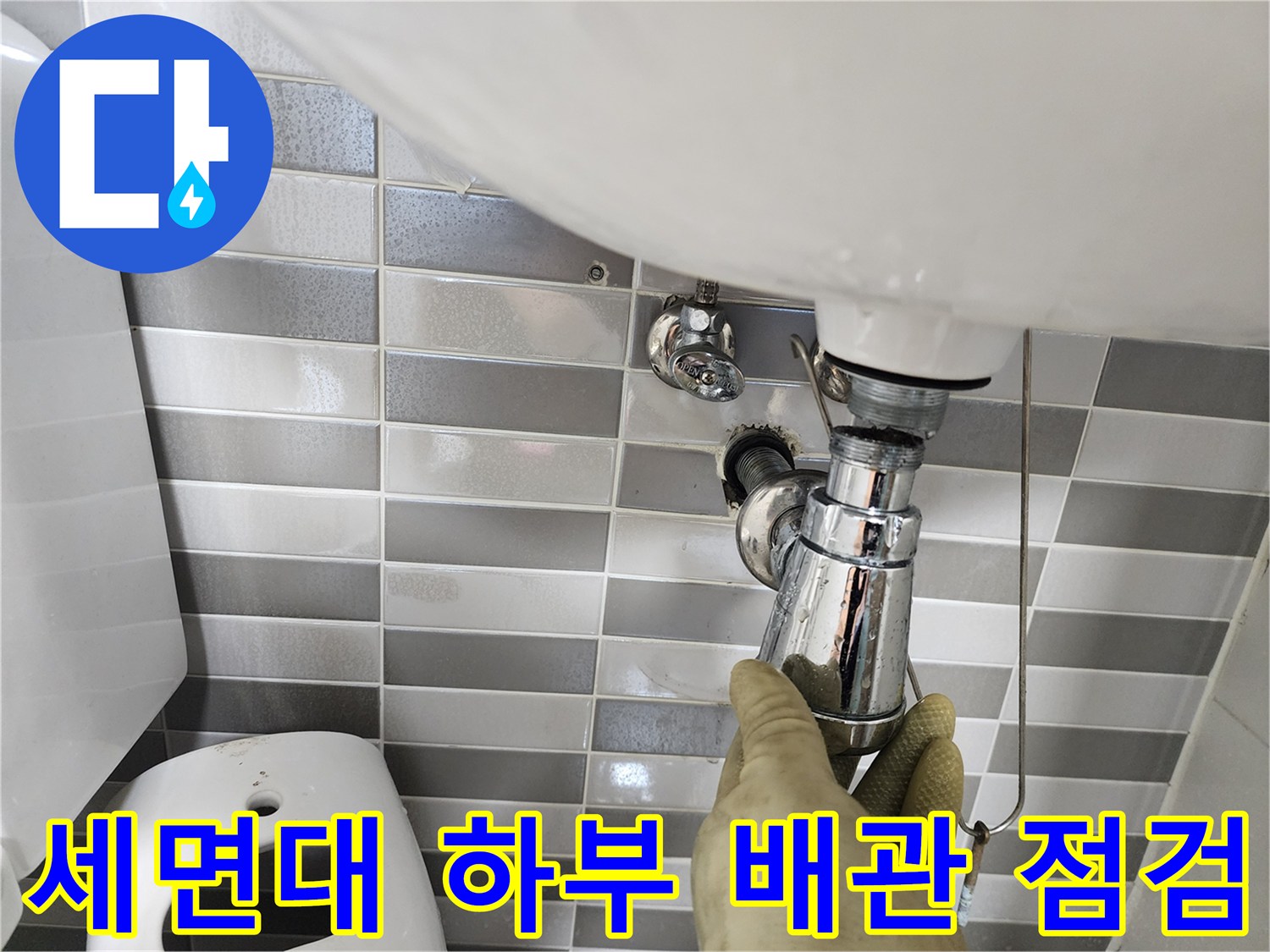 세면대 아래쪽 트랩과 연결 부위를 손으로 만지며 점검하는 모습