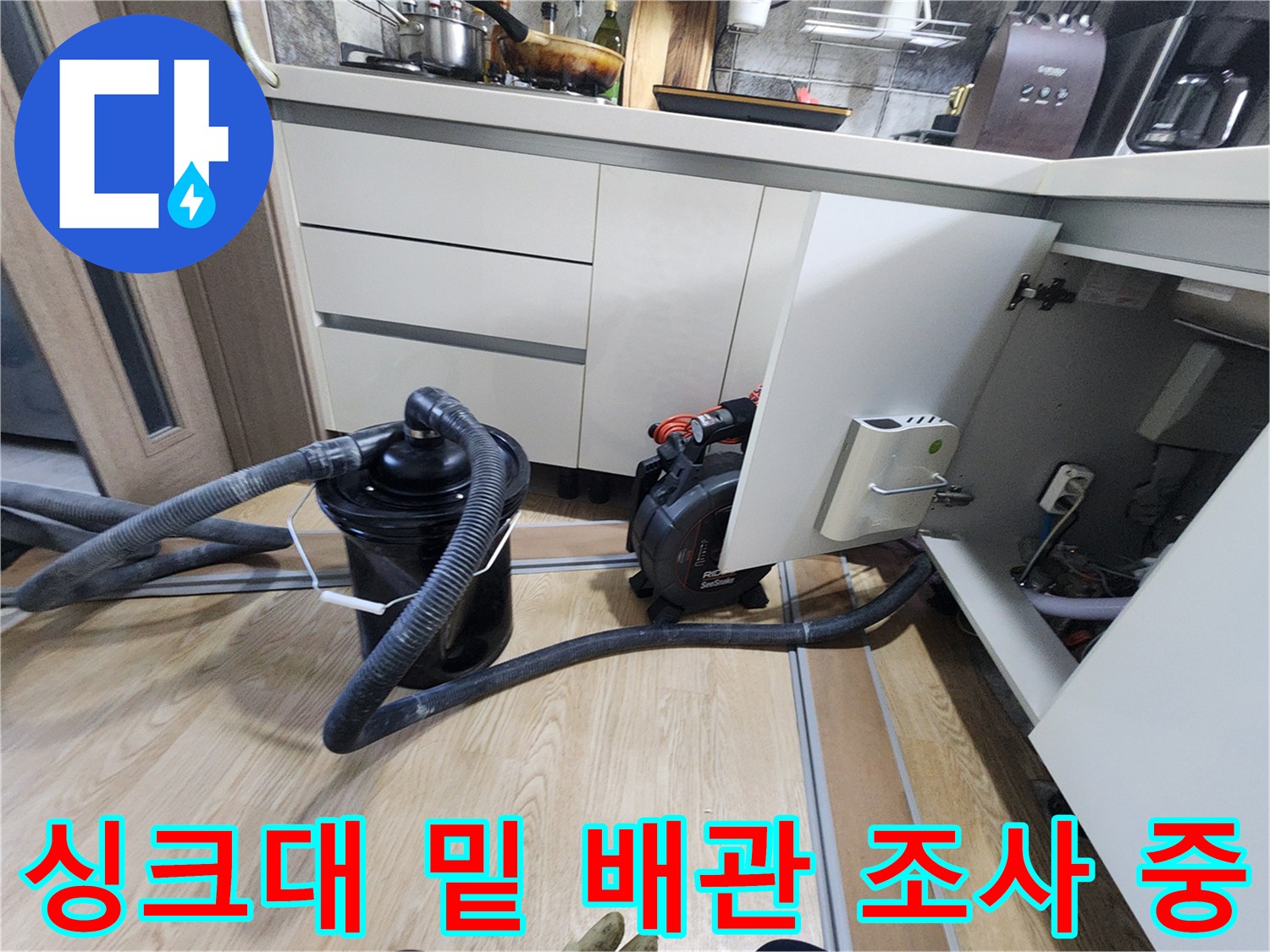 주방 싱크대 아래 배관 주변에 설치된 검사용 호스와 장비