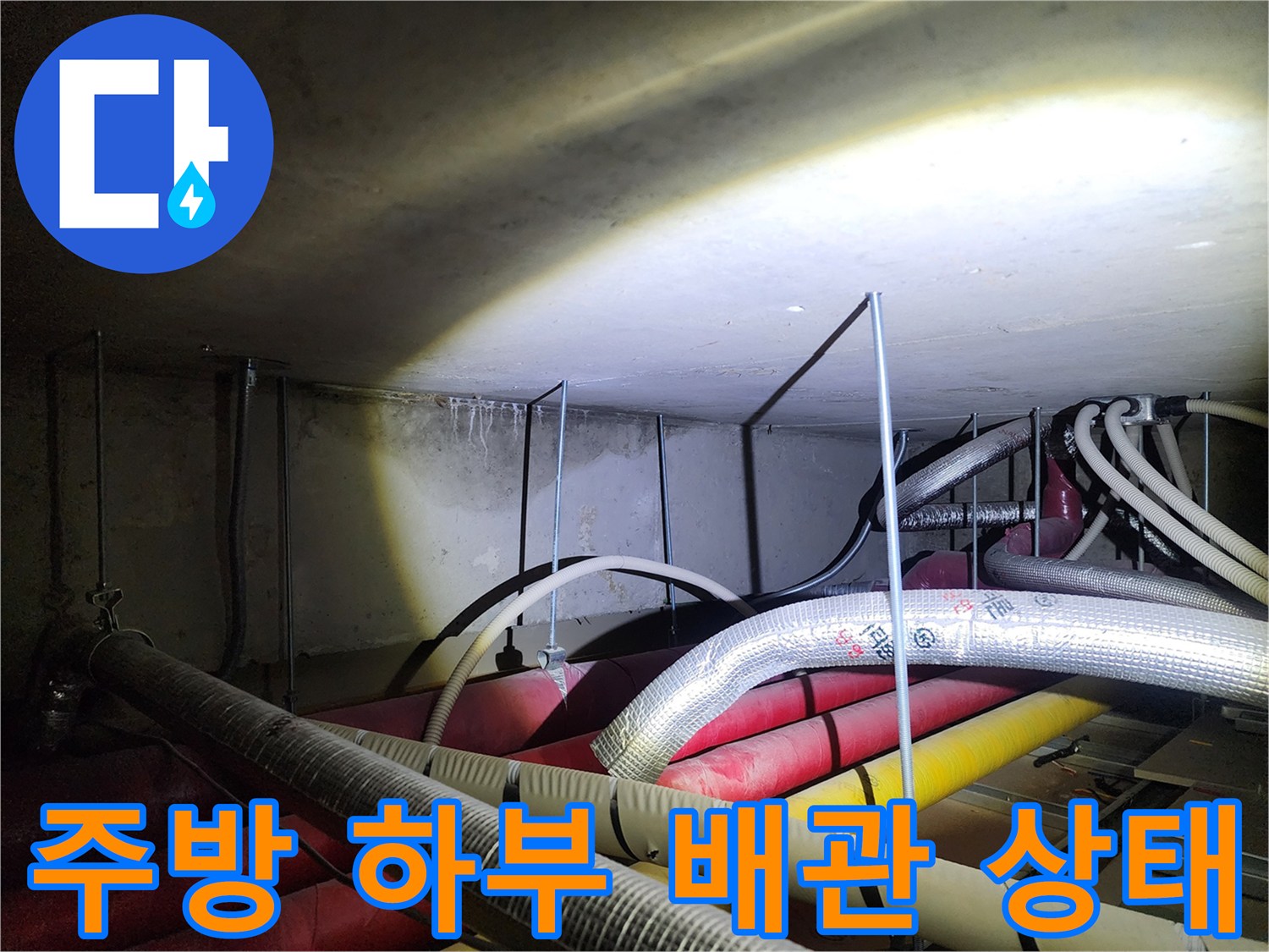 주방 천장 내부의 복잡한 배관과 노후된 연결 부위 모습
