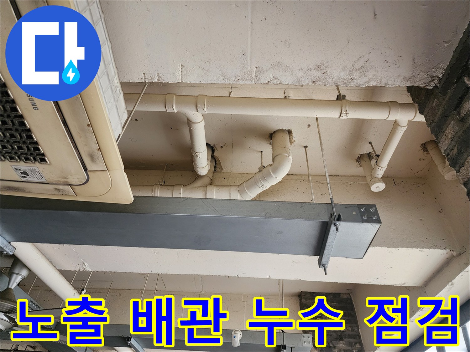 에어컨 실내기 하단부의 흰색 배관과 천장 슬라브 구조물