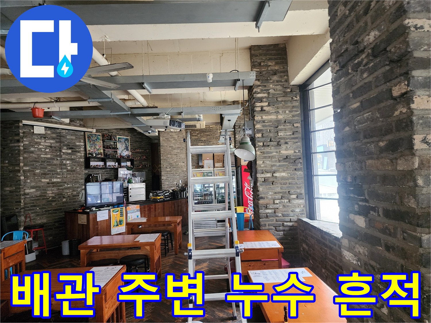 카페 천장의 노출된 배관과 벽돌 벽면의 연결 부위