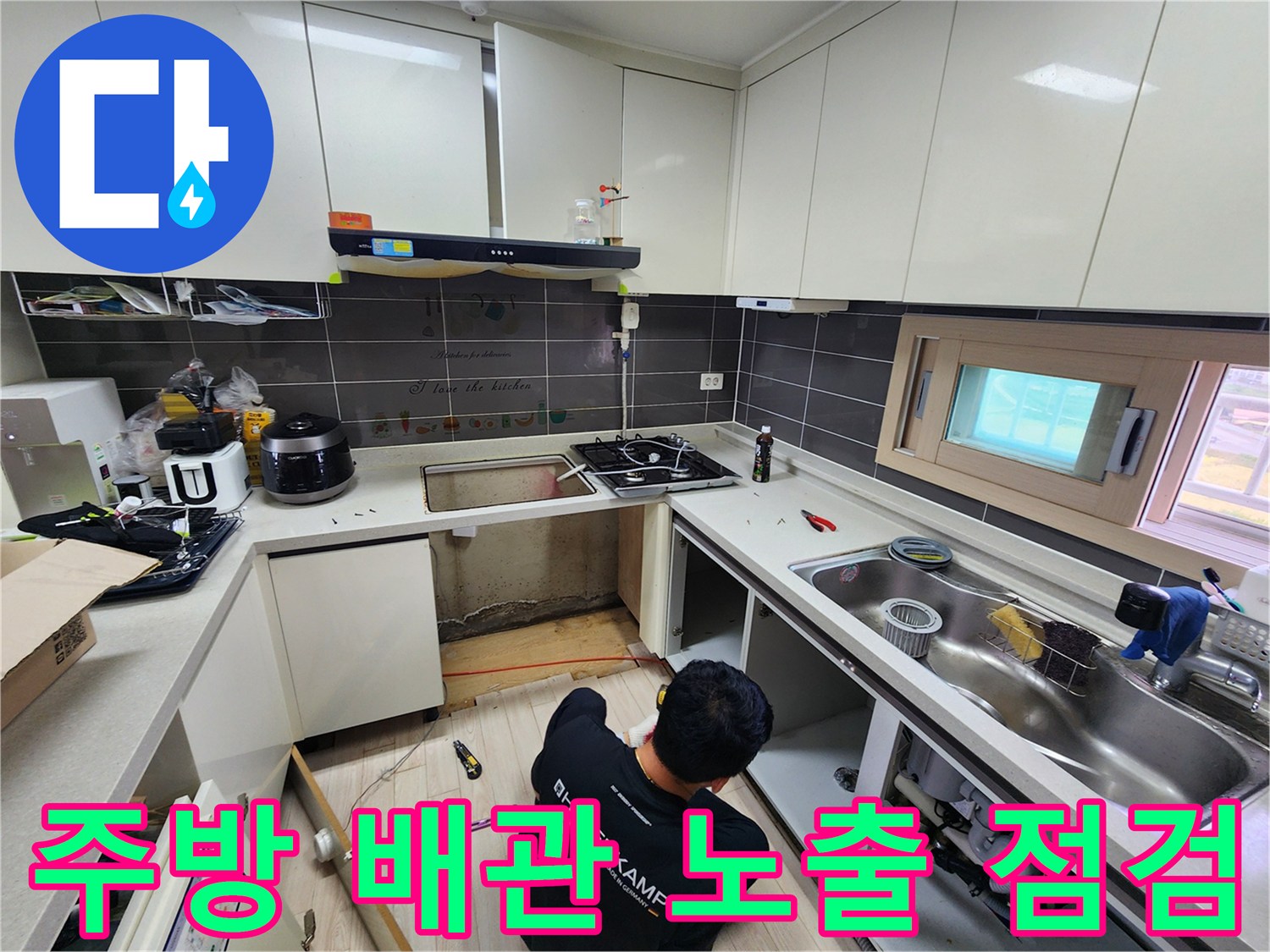 싱크대 하단부의 물샘 흔적을 찾기 위해 작업 중인 모습