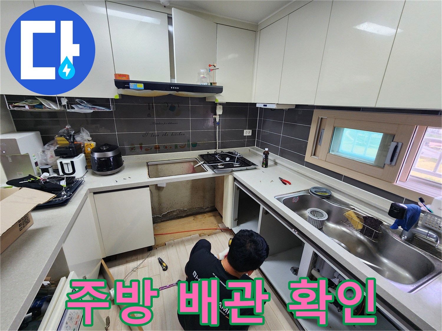 싱크대 하부장 내부의 노출된 배관과 작업 공간