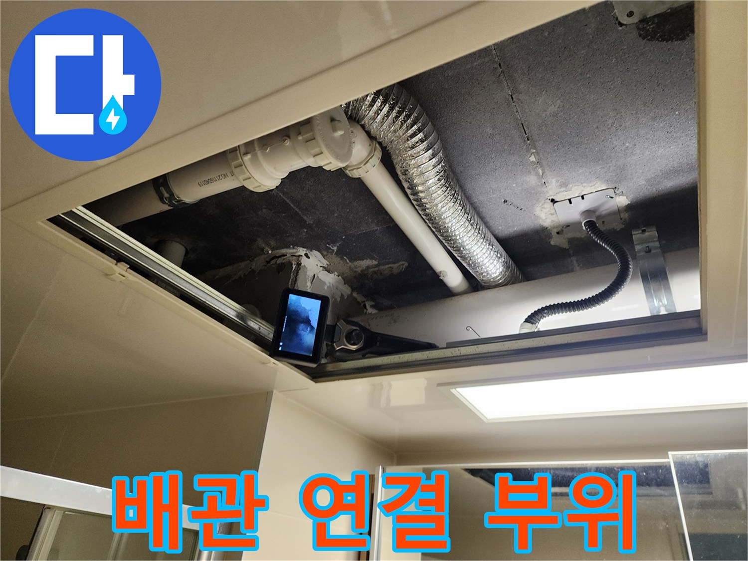 천정 내부의 하얀색 배관과 은색 환기용 자호스