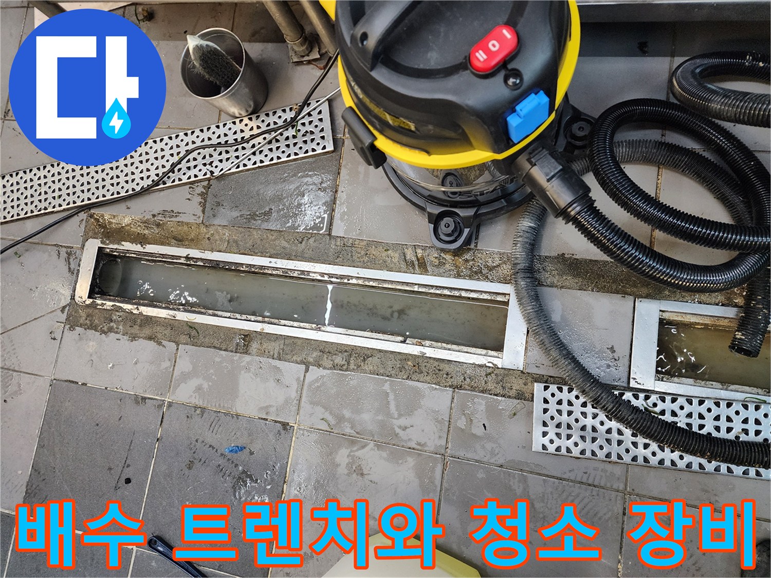 고인 물이 있는 배수 트충과 연결된 습식 청소기 호스